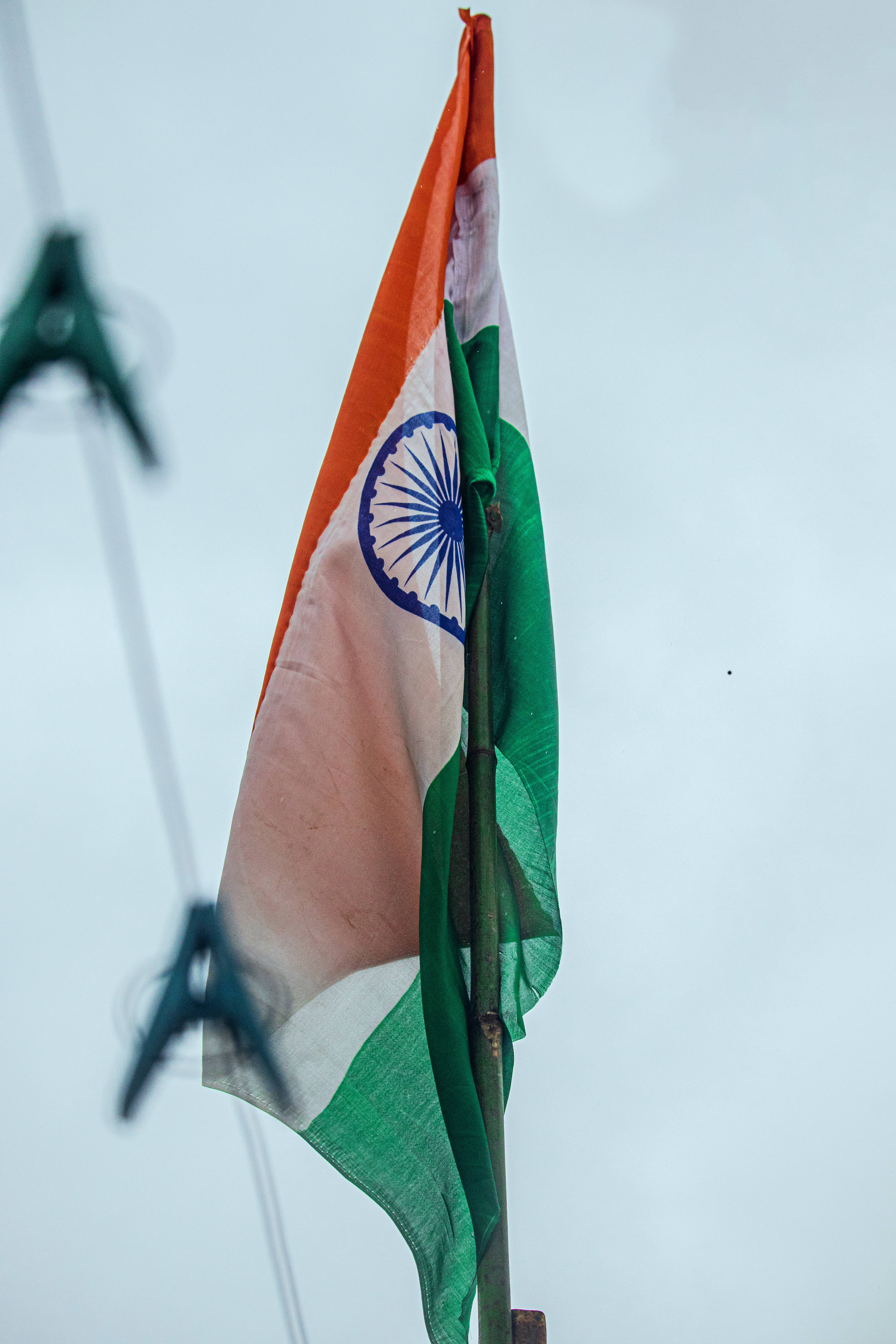 Tiranga 桌布 壁紙 — 印度國旗，帶有藏紅花、白色和綠色條紋以及藍色阿育王法輪，在蒼白的天空中飄揚。