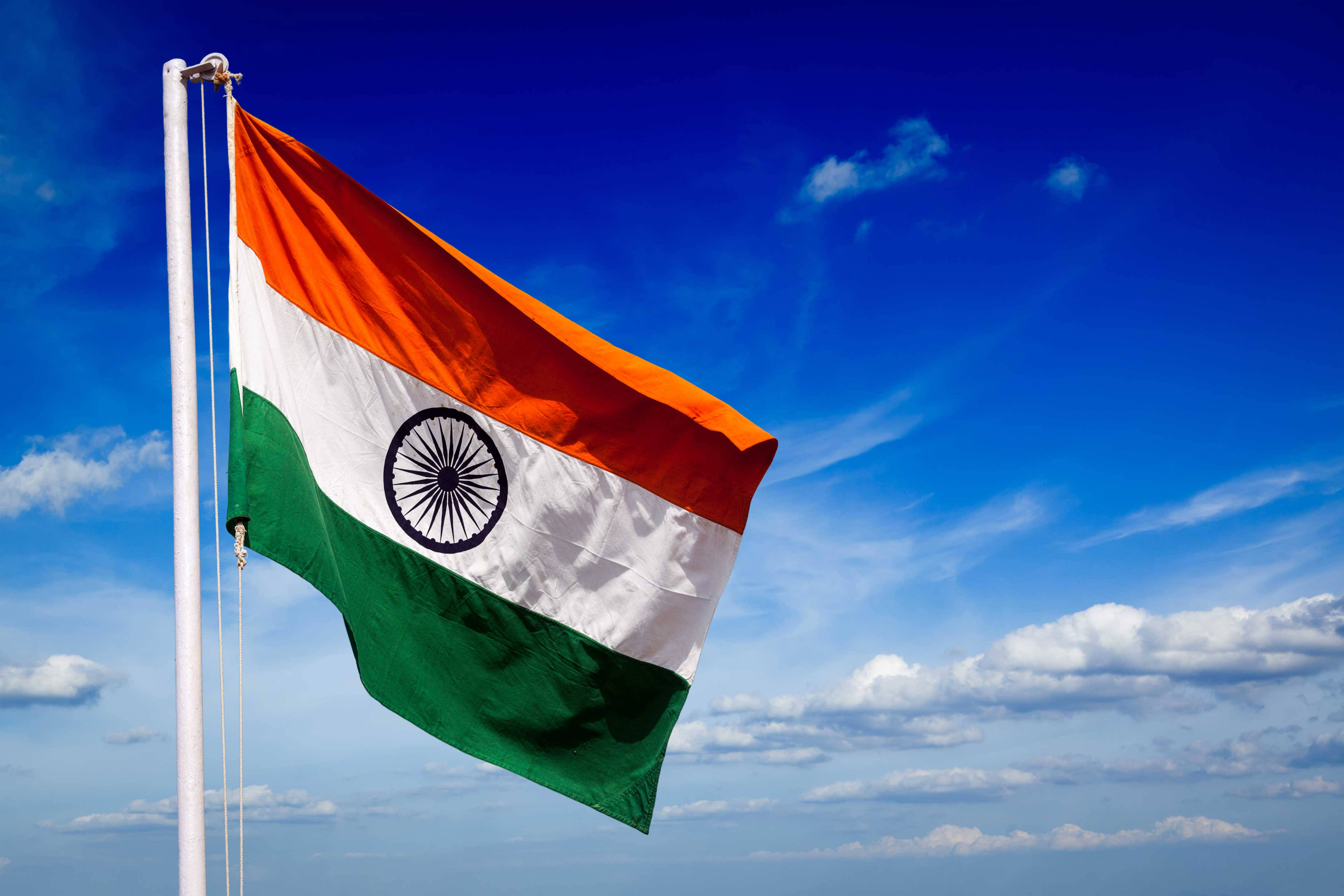 Indian 桌布 壁紙 — 印度國旗在藍天白雲下自豪地飄揚。