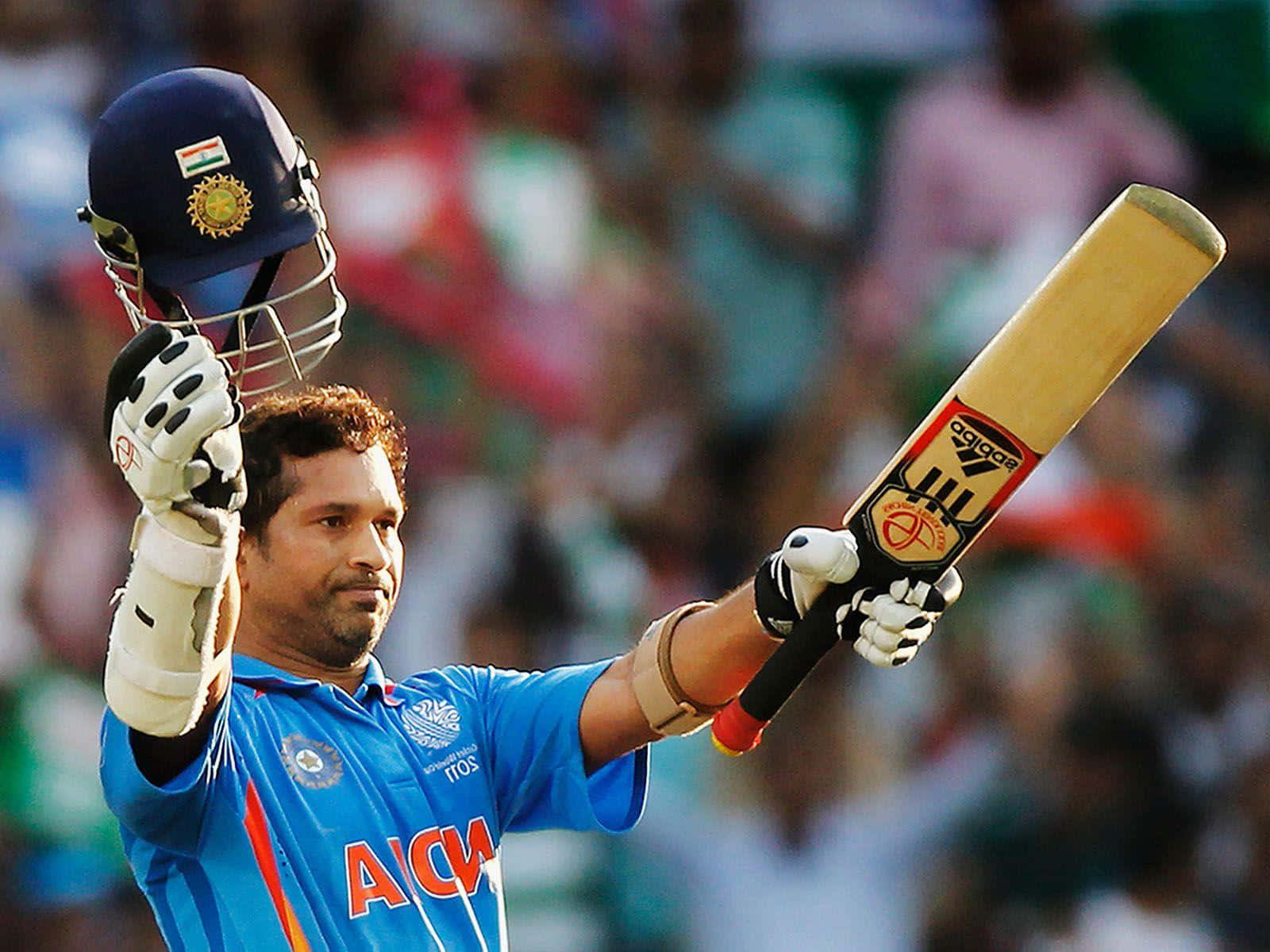 Sachin Tendulkar 桌布 壁紙 — 印度板球運動員在體育場人群中高舉頭盔和球棒慶祝。