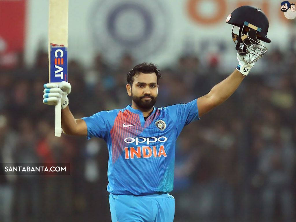 Rohit Sharma 桌布 壁紙 — 印度板球運動員在體育場燈光下高舉球棒和頭盔慶祝勝利。