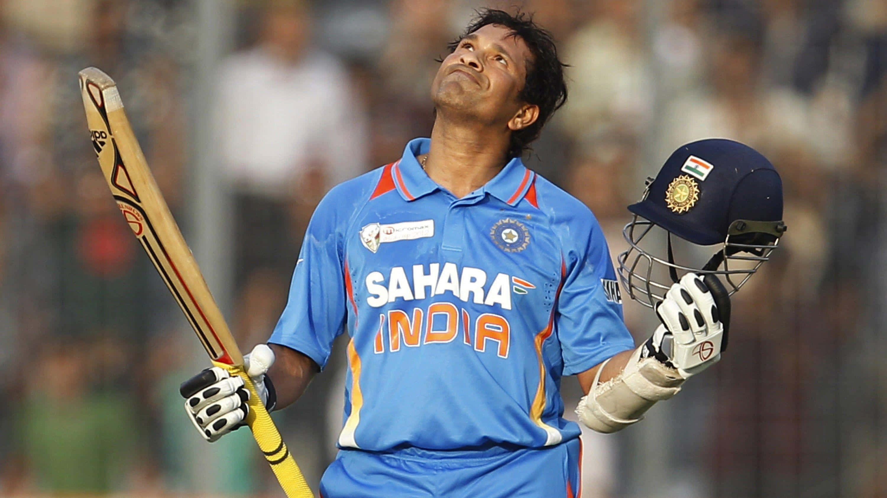 Sachin Tendulkar 桌布 壁紙 — 印度板球運動員身穿藍色Sahara India球衣，在球場上手持球棒和頭盔向上看。