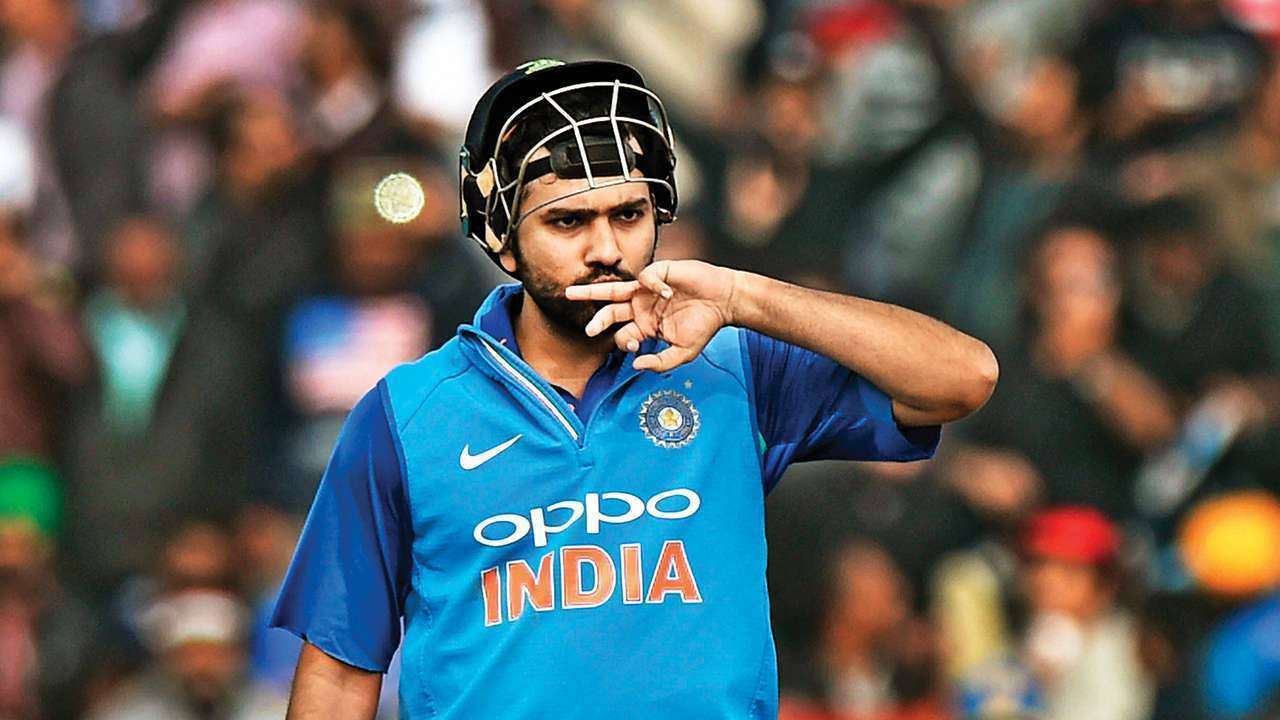 Rohit Sharma 桌布 壁紙 — 印度板球運動員身穿藍色球衣和頭盔，在擁擠的體育場上做出手勢。