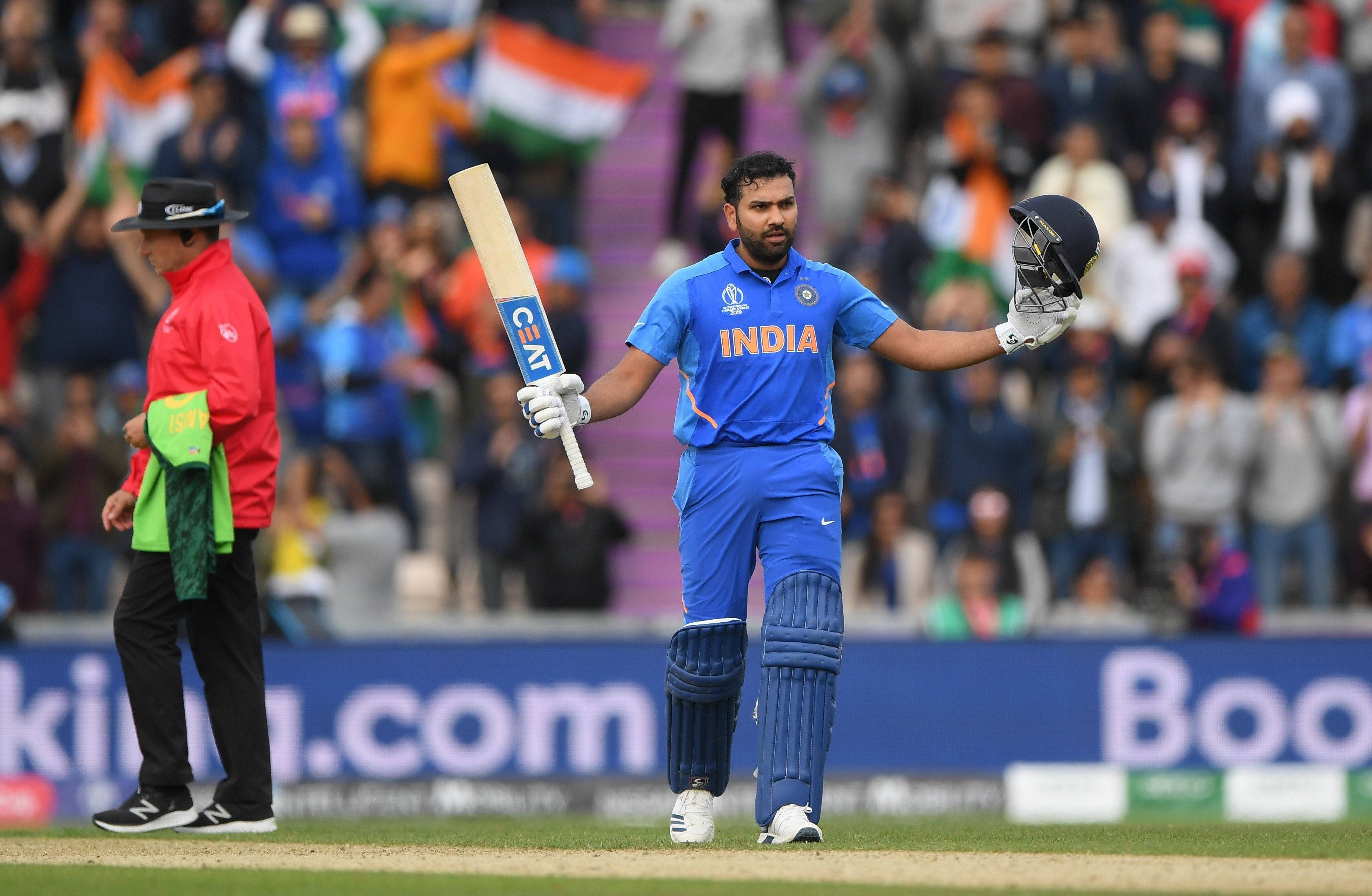 Rohit Sharma 桌布 壁紙 — 印度板球運動員高舉球棒和頭盔慶祝，身後人群歡呼。