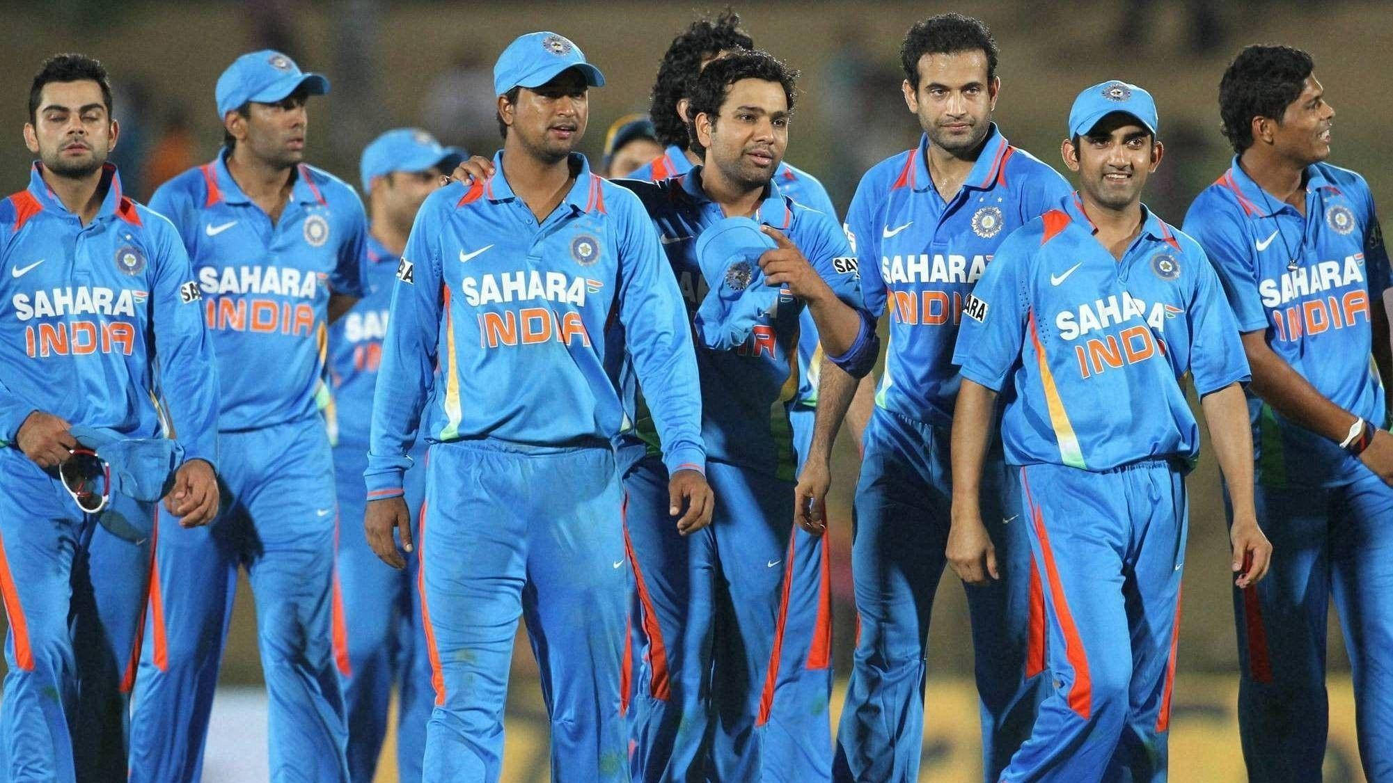 運動 桌布 壁紙 — 印度板球隊身穿藍色Sahara India制服，在明亮的燈光下一同站在體育場上。