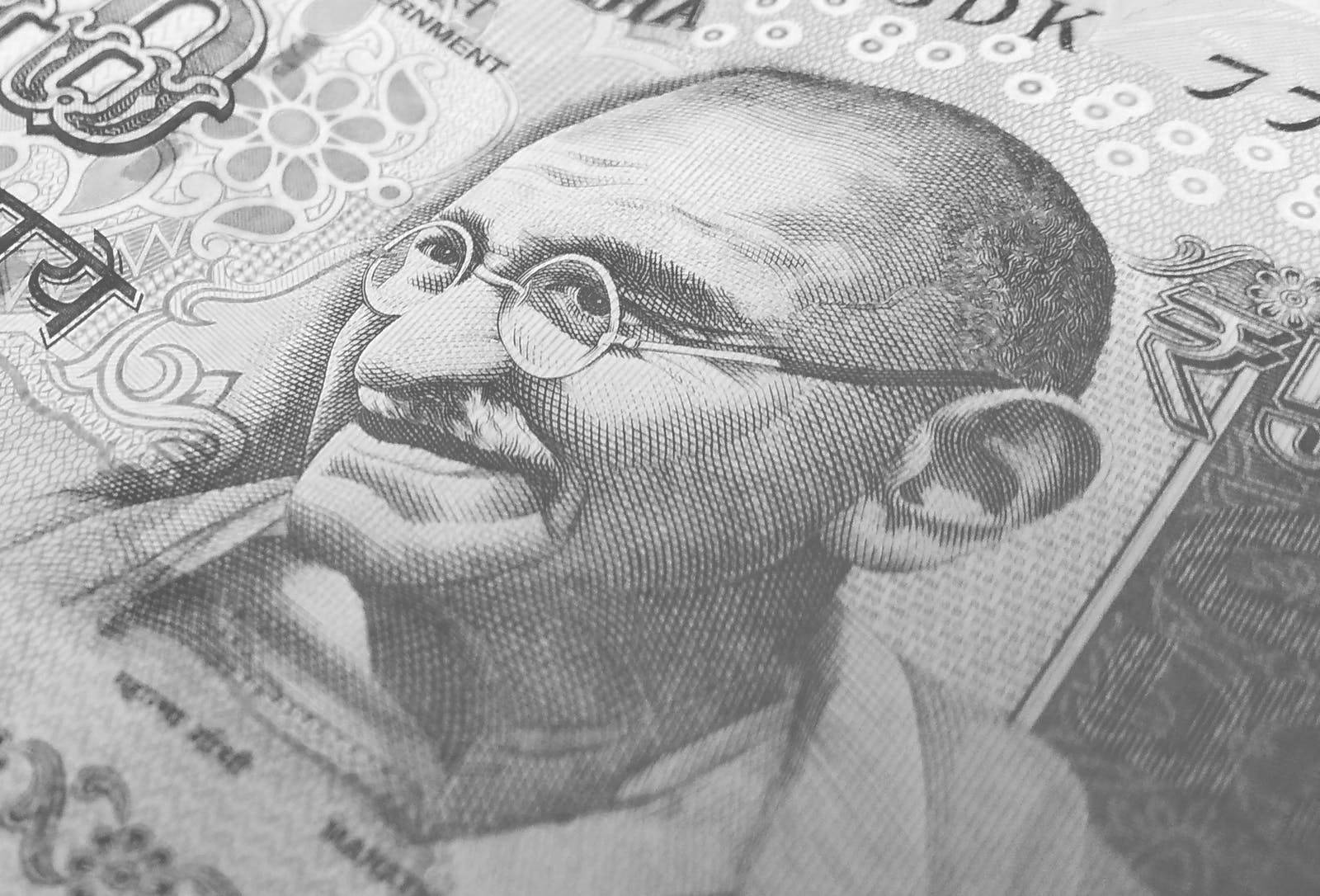 Mahatma Gandhi 桌布 壁紙 — 印度盧比紙幣上聖雄甘地肖像的特寫，帶有複雜的雕刻細節和華麗圖案。