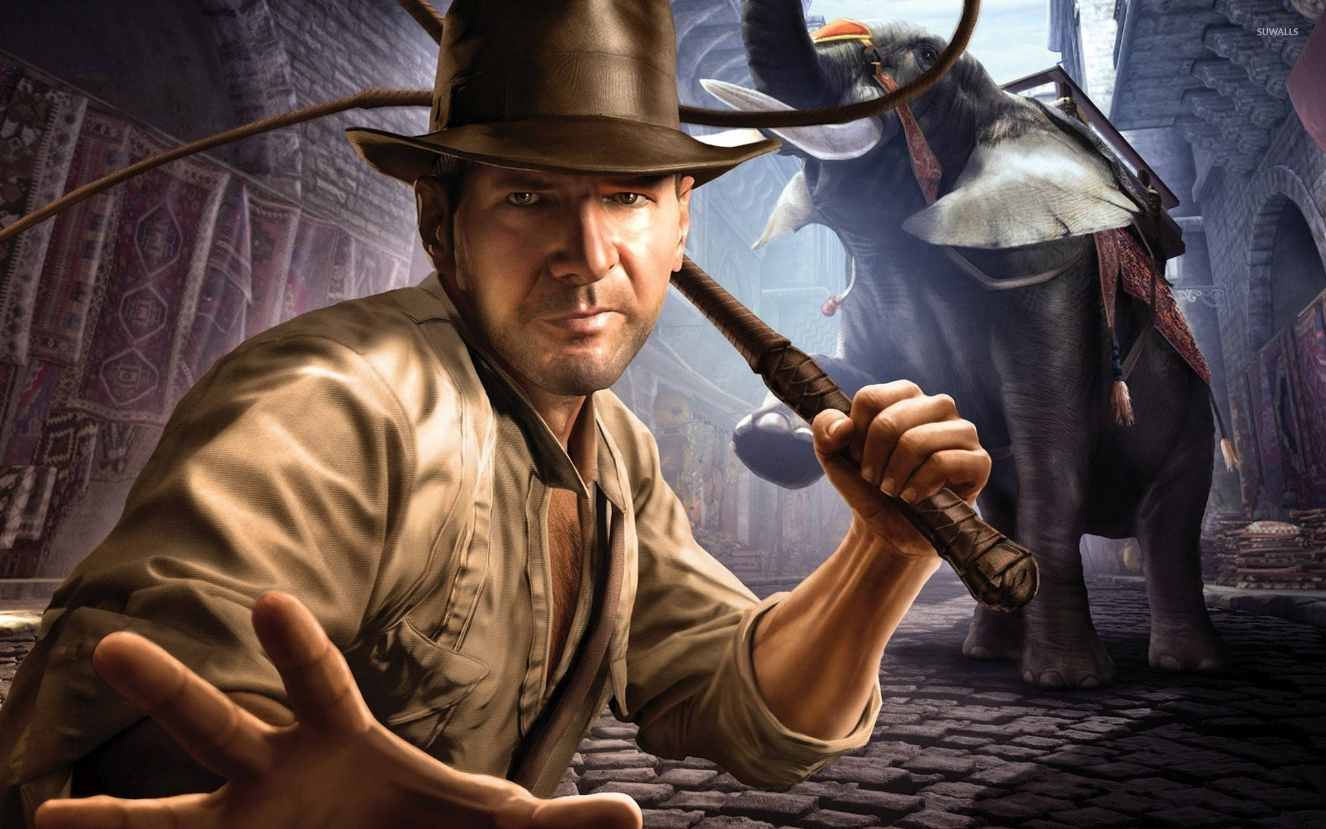 Indiana Jones 桌布 壁紙 — 印第安納瓊斯在塵土飛揚的寺廟庭院中手持鞭子，身後站著一頭裝飾華麗的大象。