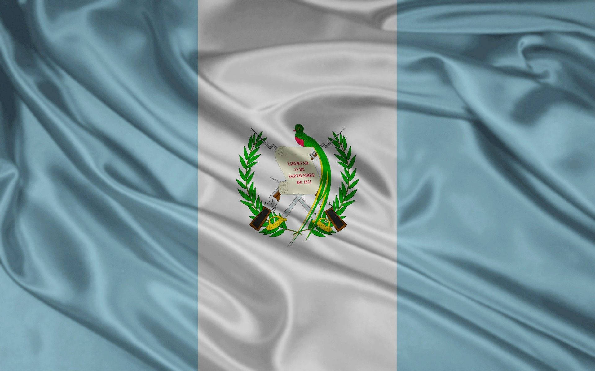 Guatemala 桌布 壁紙 — 厄瓜多國旗的特寫，帶有藍、白、綠條紋和中央盾徽，在飄逸的緞面布料上。