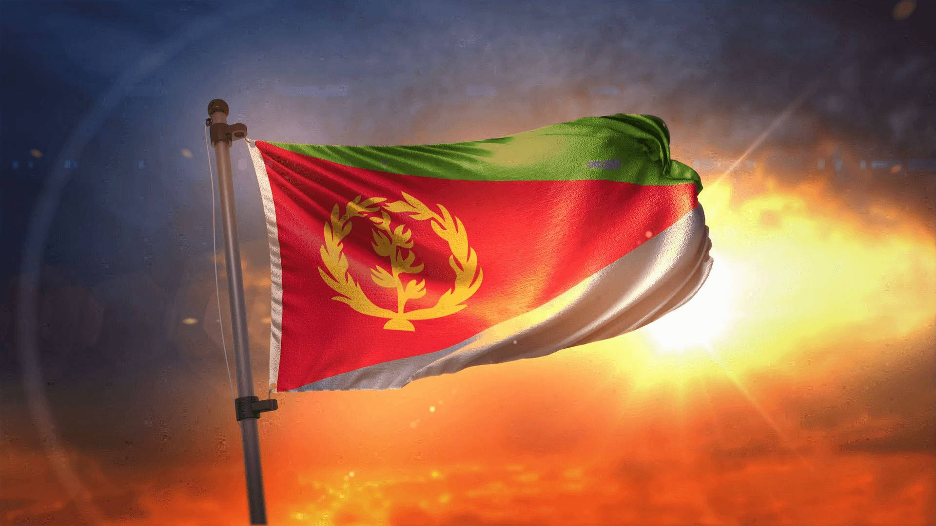 Eritrea 桌布 壁紙 — 厄立特里亞國旗在火紅的日落天空下自豪地飄揚，伴隨著耀眼的陽光和戲劇性的雲彩。