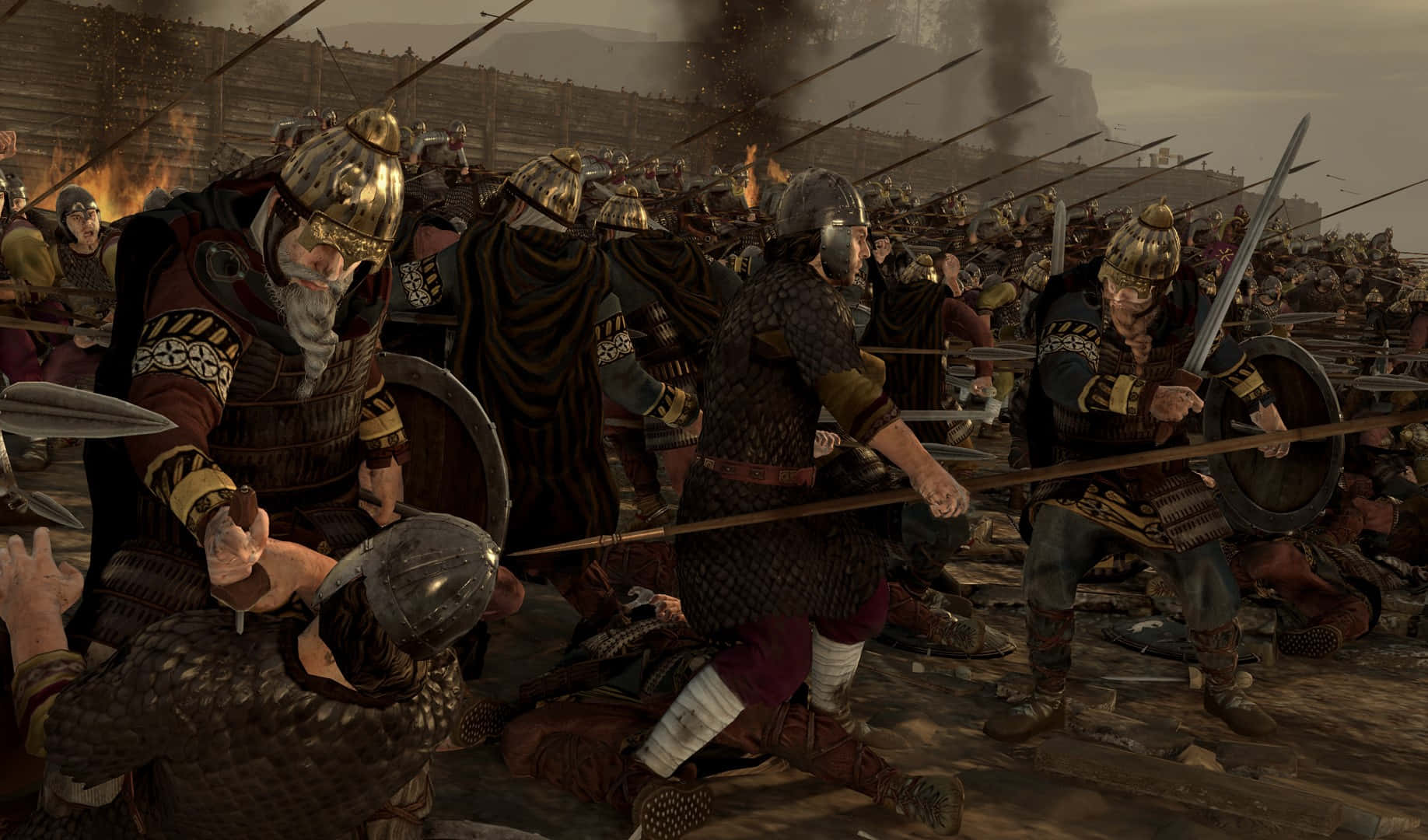 Total War Attila 桌布 壁紙 — 古代戰士身穿精細盔甲，在煙霧瀰漫的戰場上激烈交鋒，周圍有燃燒的建築物和倒下的士兵。