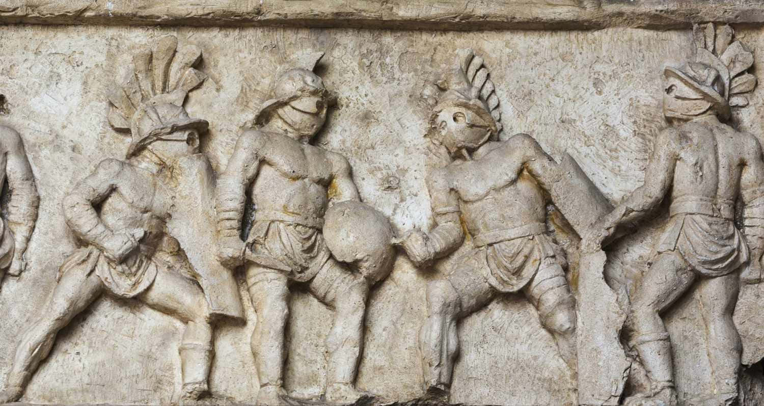 Gladiator 桌布 壁紙 — 古代石浮雕，描繪身穿盔甲的戰士以頭盔和盾牌擺出動態戰鬥姿勢。
