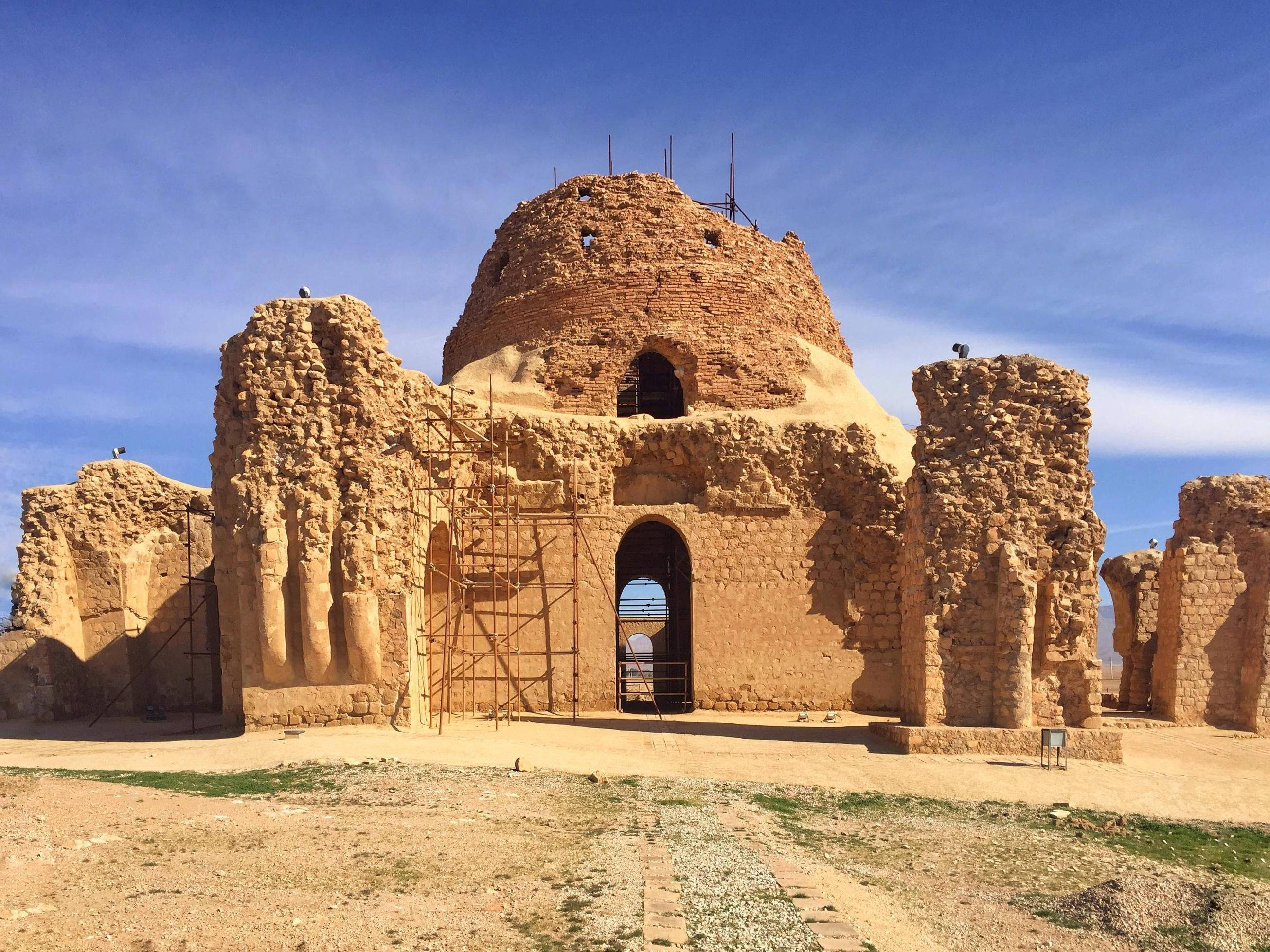 Iran 桌布 壁紙 — 古代石砌遺跡，圓頂結構，在清澈藍天下，設有修復用的鷹架。