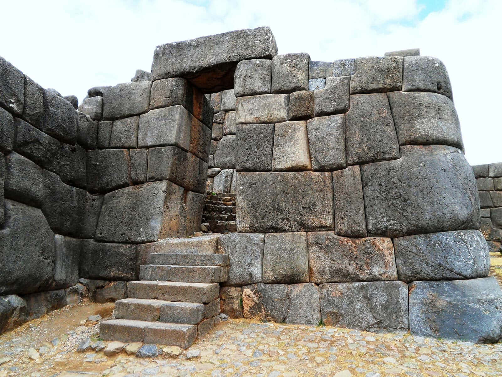 Attraction 桌布 壁紙 — 古代石造遺跡，巨大且精確拼接的石塊在明亮天空下形成門口和樓梯。