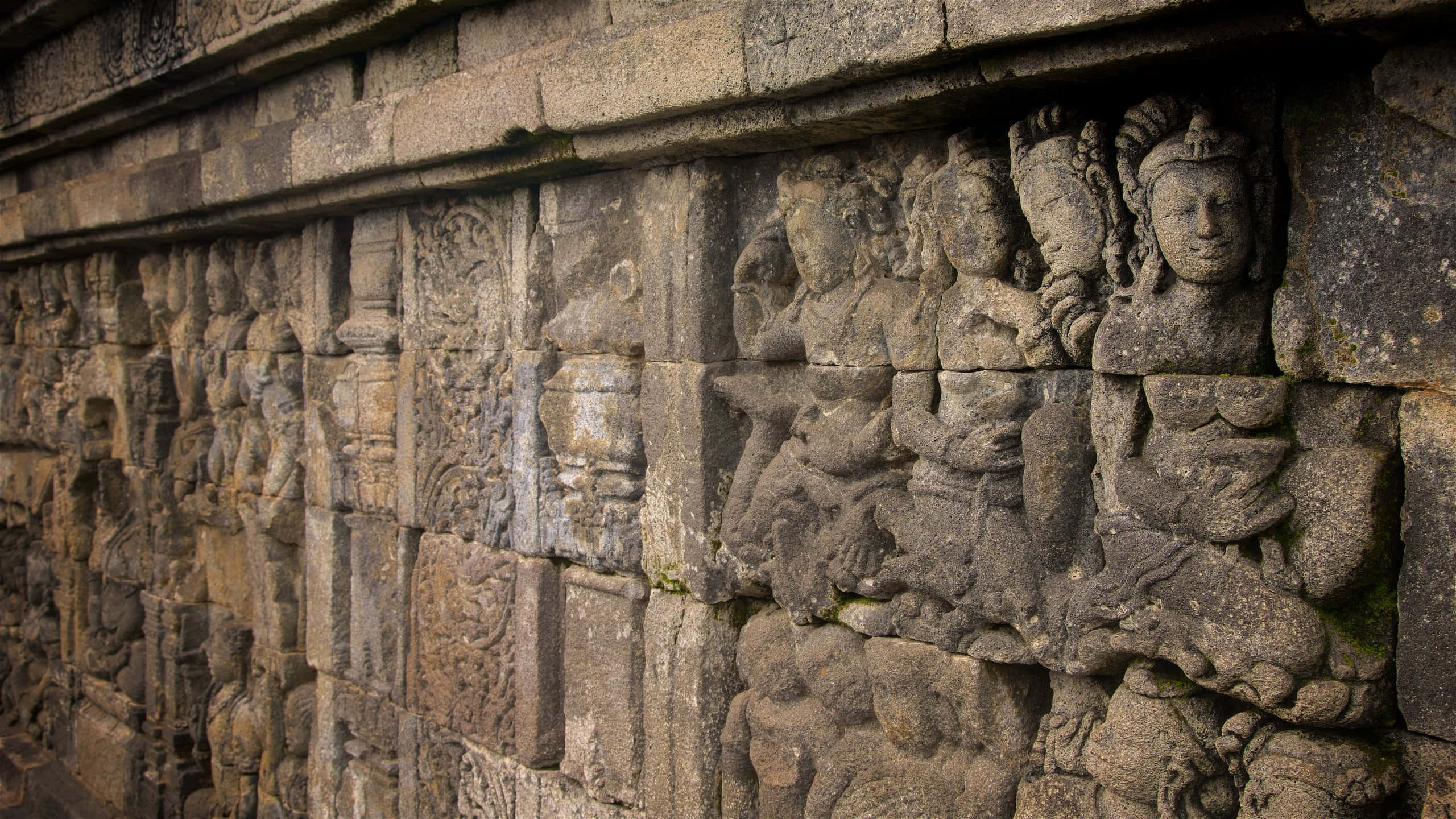 廟宇 桌布 壁紙 — 古代石雕在風化的寺廟牆上以精細浮雕描繪寧靜的人物。