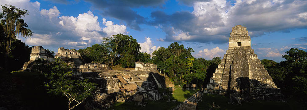 Guatemala 桌布 壁紙 — 古代馬雅石金字塔從茂密的叢林中升起，在戲劇性的多雲天空下。
