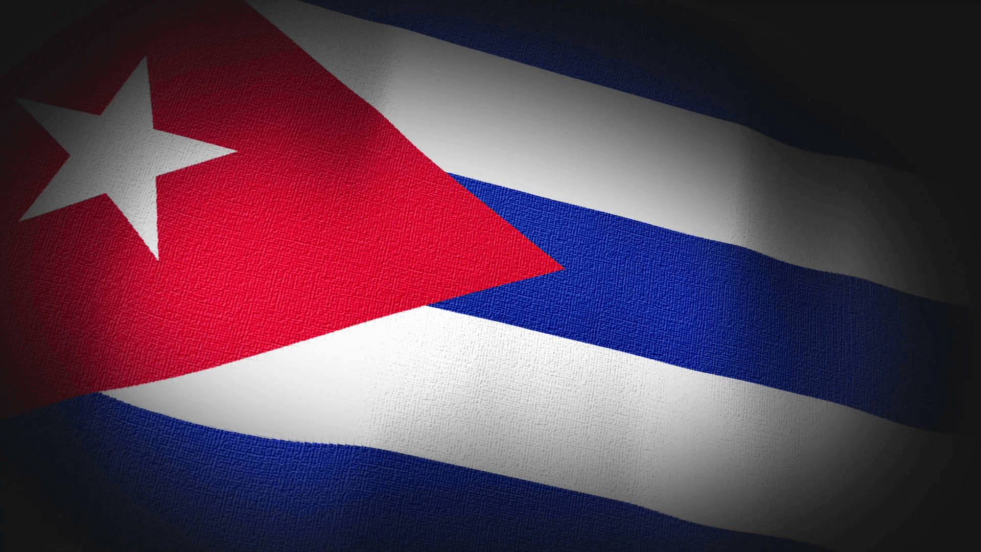 Cuban 桌布 壁紙 — 古巴國旗，帶有紅、白、藍條紋，紅色三角形上有一顆白色星星，在戲劇性聚光燈下在紋理布料中飄揚。