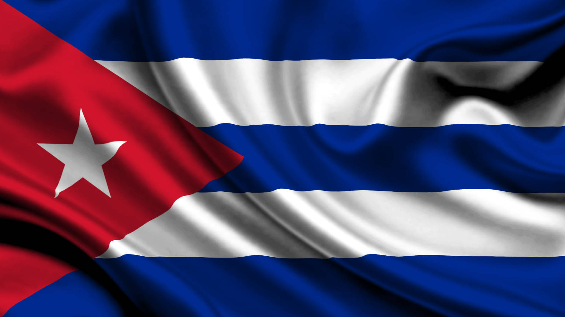 Cuban 桌布 壁紙 — 古巴國旗，帶有紅色三角形、白色星星和藍白條紋，在微風中飄揚。