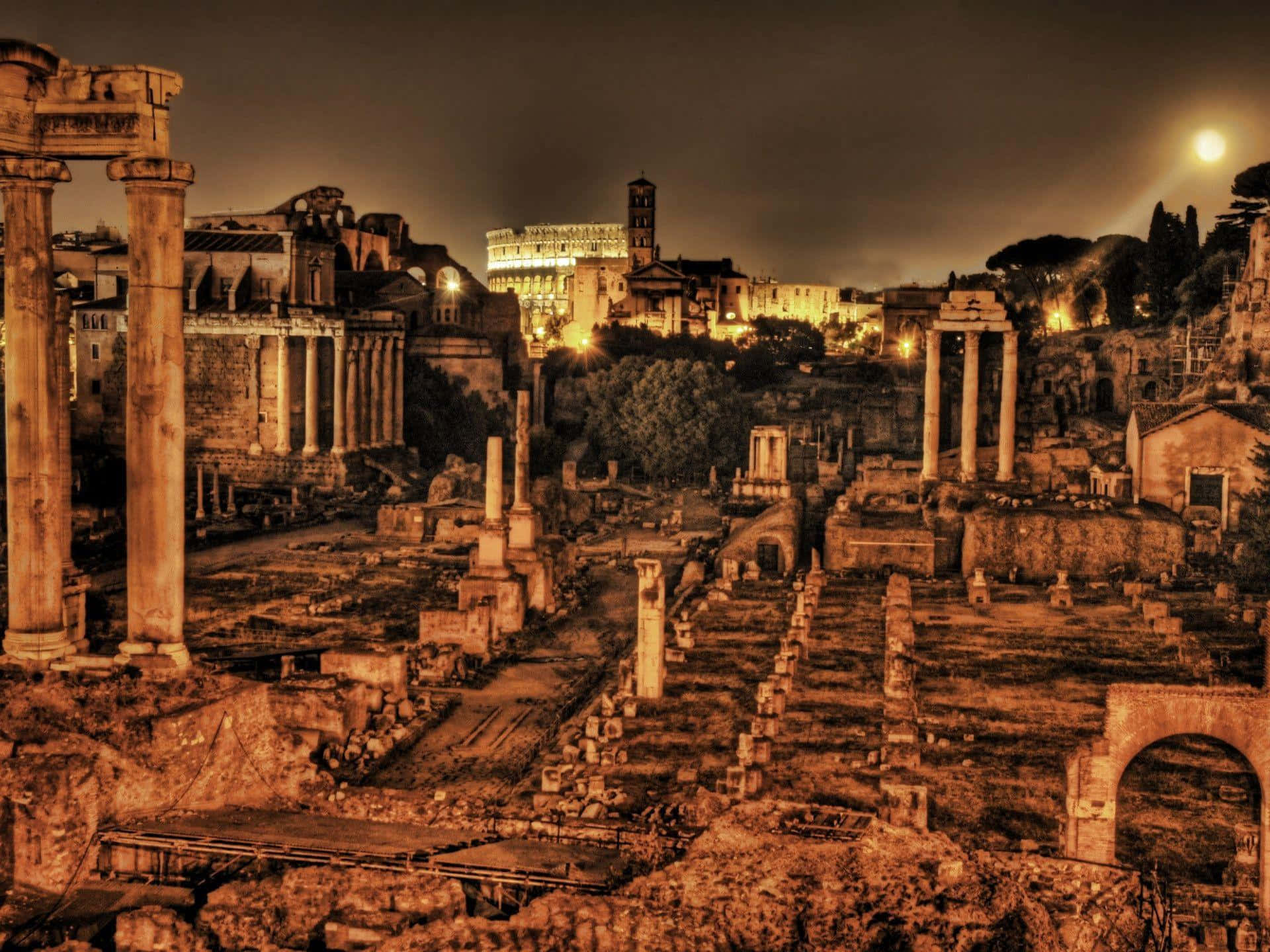 Rome 桌布 壁紙 — 古羅馬遺跡在明亮的月光下溫暖地發光，遠處的羅馬競技場被照亮。