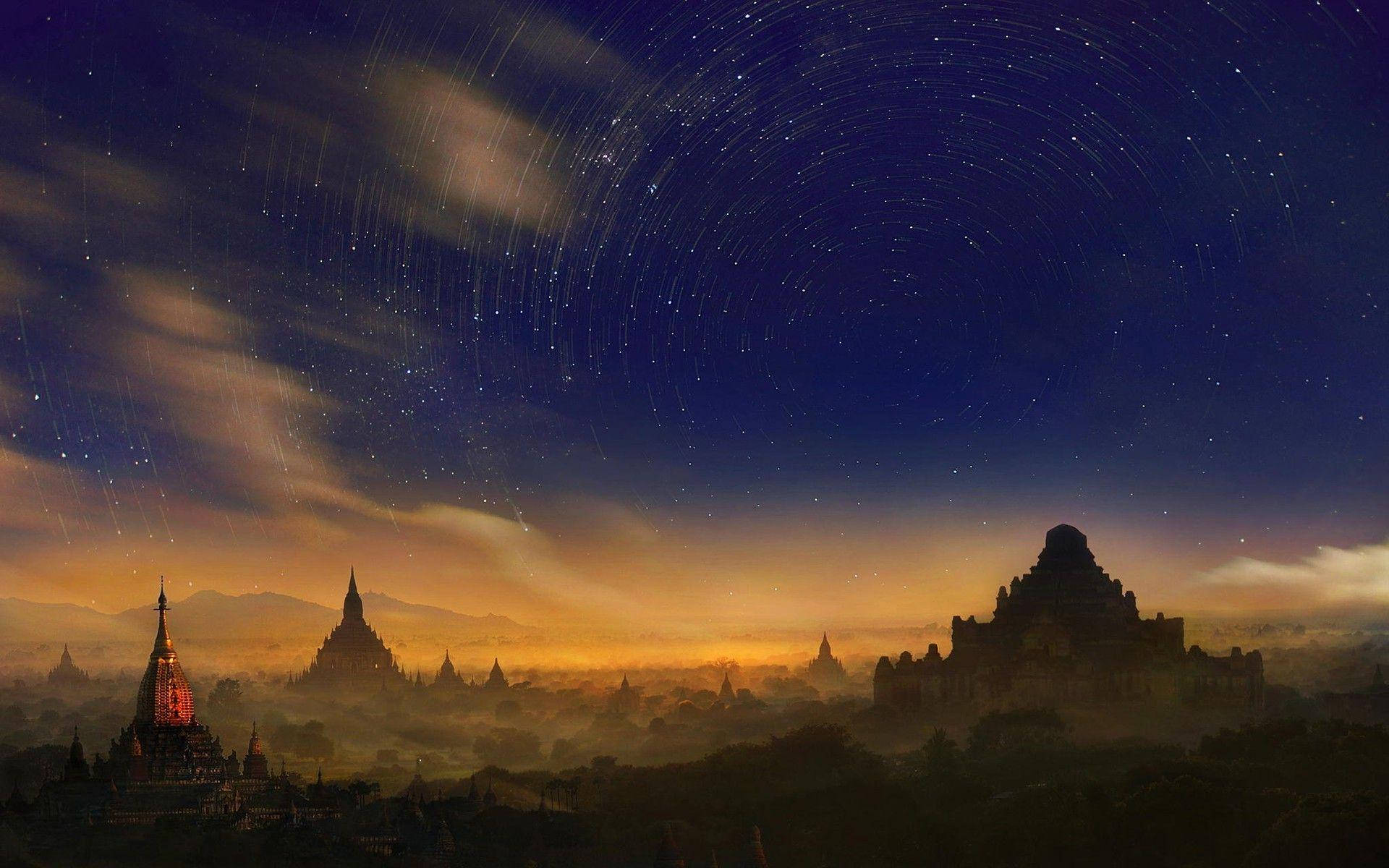 Burma 桌布 壁紙 — 古老寶塔在繁星點點的夜空下形成剪影，上方有戲劇性的星軌弧線。