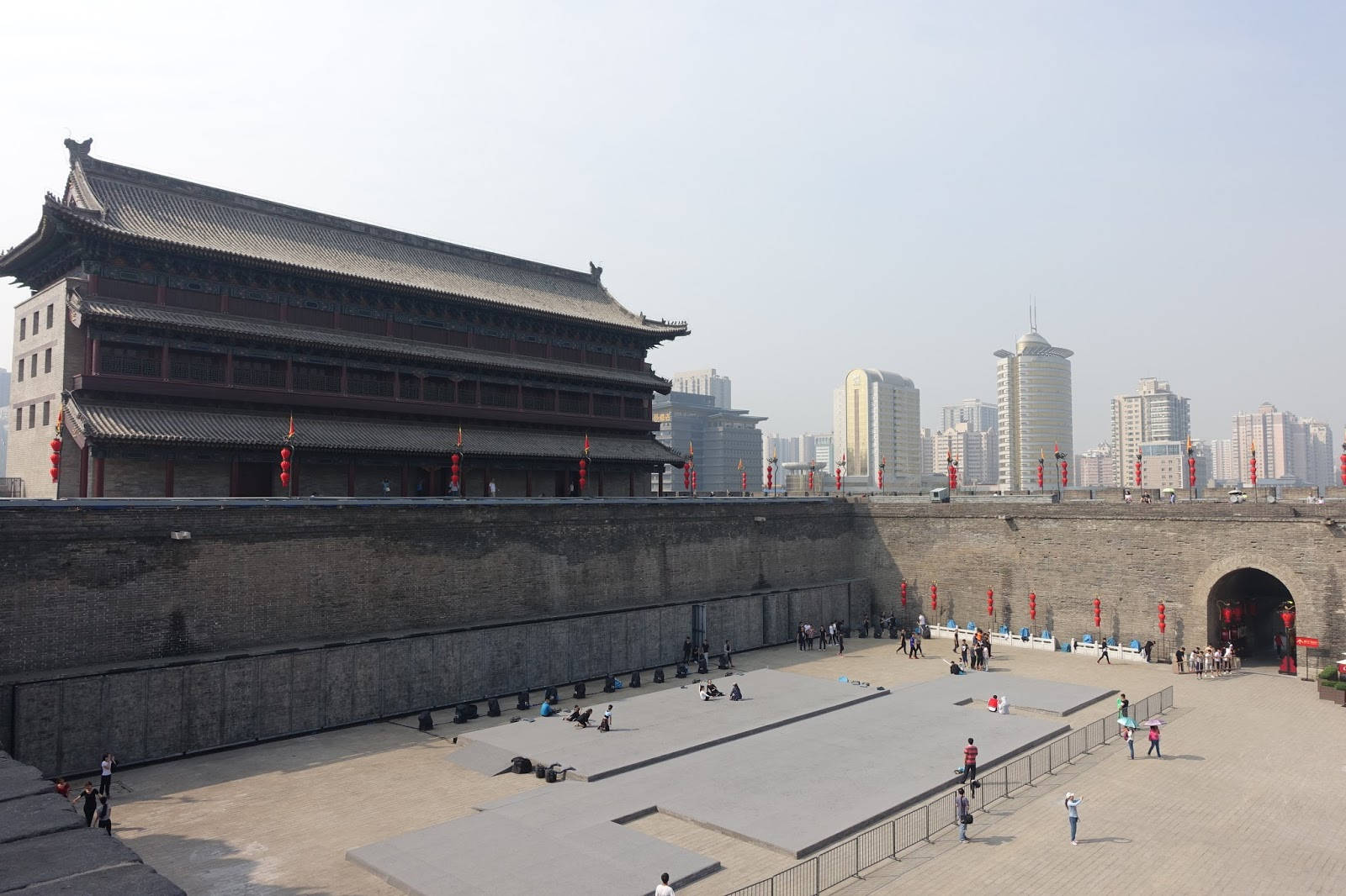 Xian 桌布 壁紙 — 古老的中國城門，帶有傳統瓦頂，在朦朧的日光下矗立在現代摩天大樓旁。