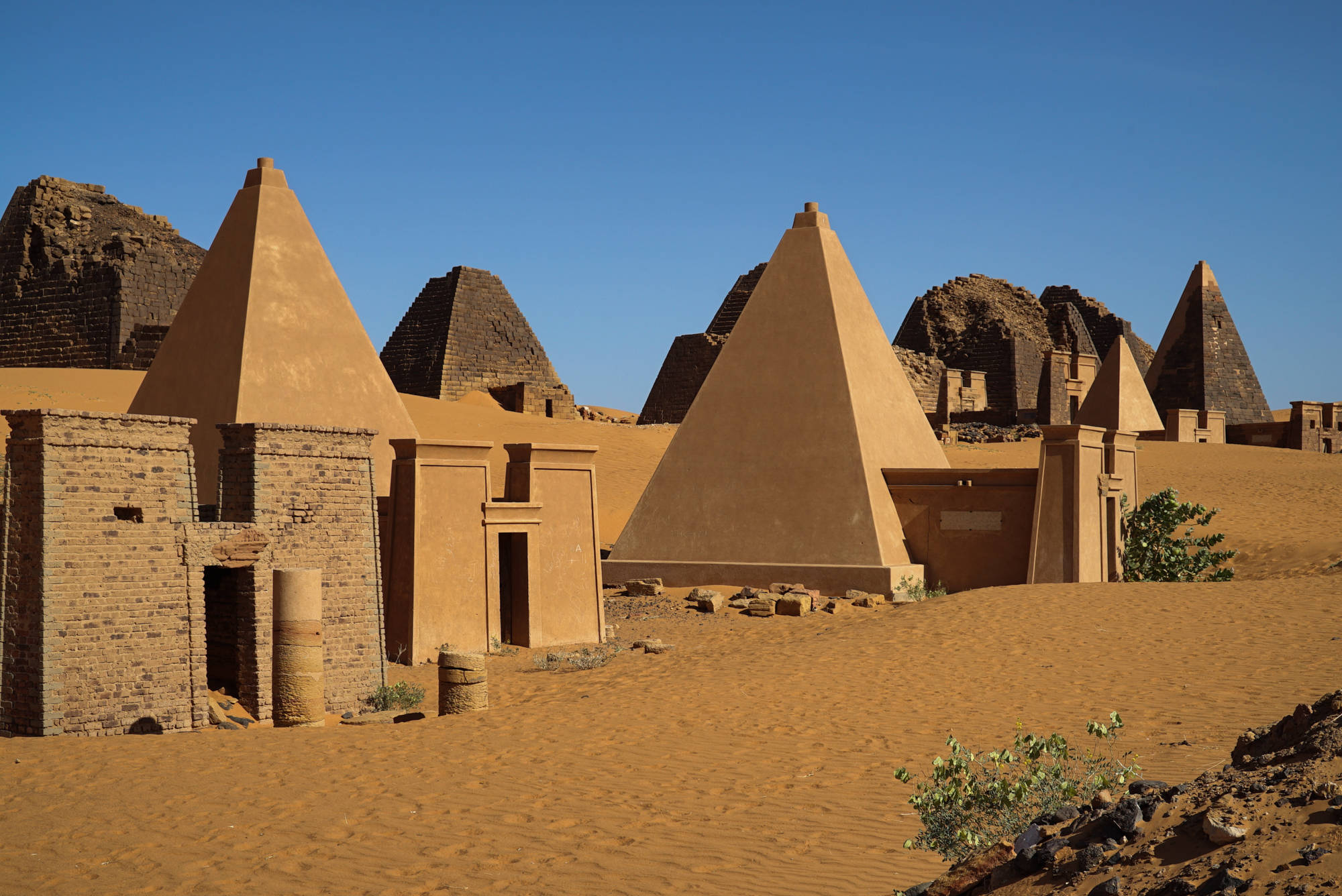 Sudan 桌布 壁紙 — 古老的泥磚金字塔和建築物在清澈的藍天下從金色沙漠中升起。