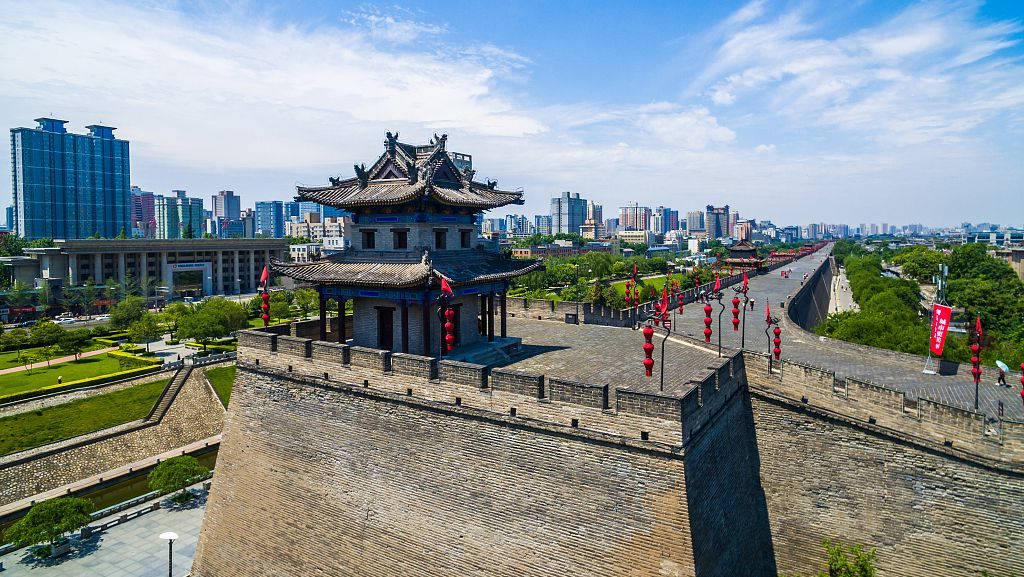 Xian 桌布 壁紙 — 古老的石城牆帶有傳統塔樓和紅色燈籠，在明亮的藍天下延伸至現代摩天大樓旁。