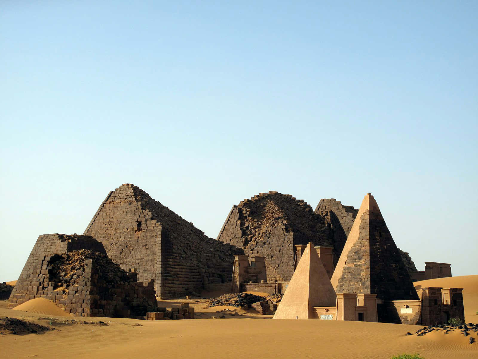 Ancient Egypt 桌布 壁紙 — 古老的石造金字塔在廣闊的金色沙漠中，在晴朗的藍天下，顯得風化而宏偉。