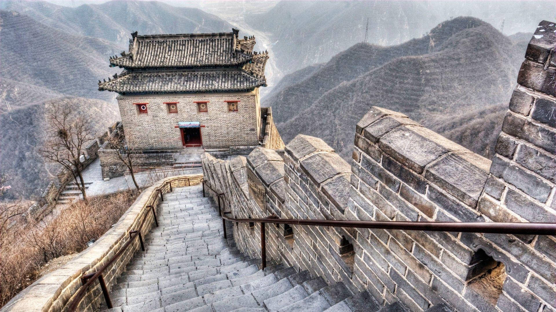 Beijing 桌布 壁紙 — 古老的石階向上延伸，通往一座坐落在霧氣繚繞山脊上的傳統中式瞭望塔。