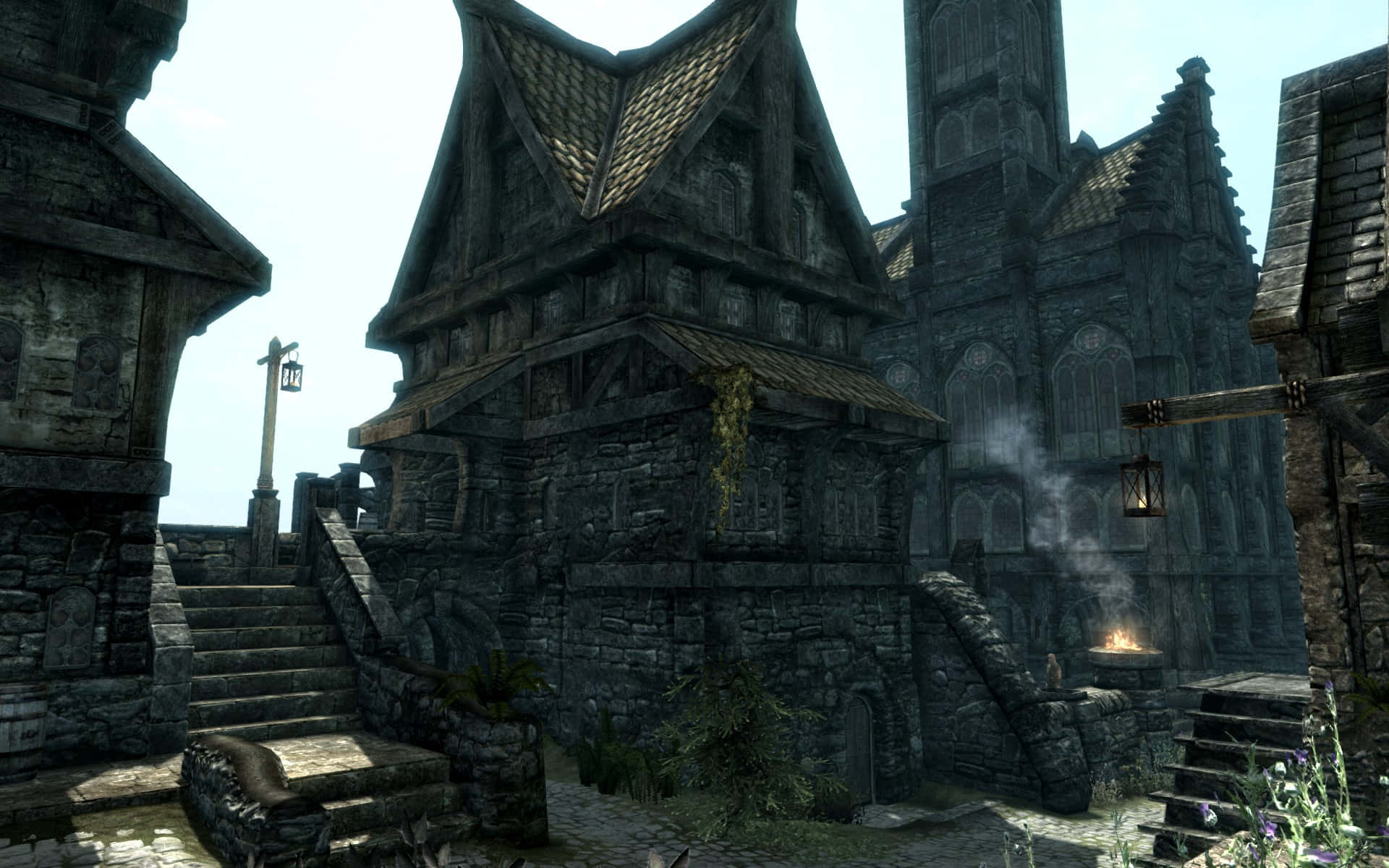 Skyrim Solitude 桌布 壁紙 — 古老的石頭和木造建築，擁有陡峭的屋頂和常春藤，在明亮的日光下生長在一個中世紀奇幻村莊中。