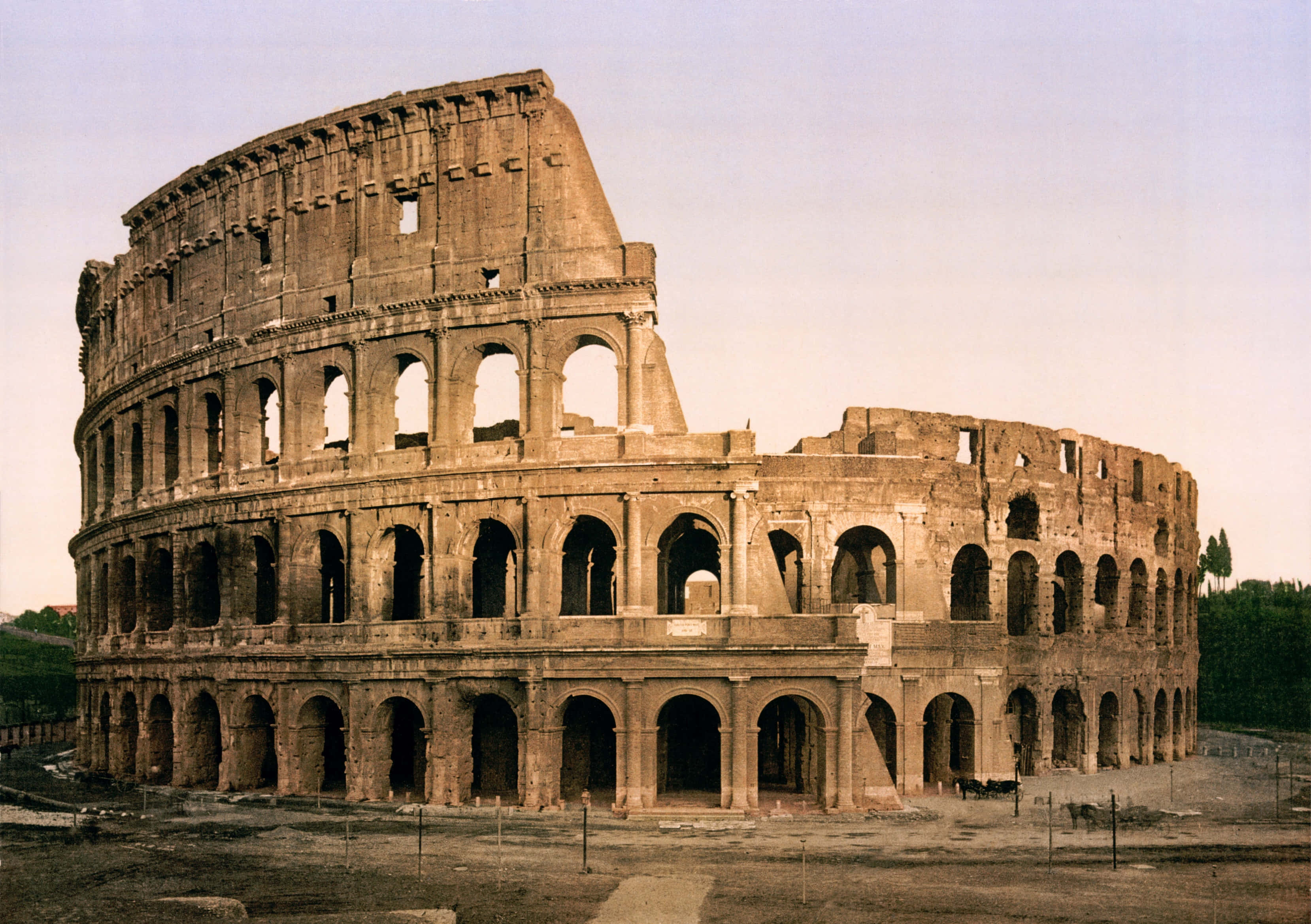 Roman 桌布 壁紙 — 古老的羅馬競技場在羅馬雄偉地矗立，其標誌性的拱門和風化的石頭在柔和天空下展現。