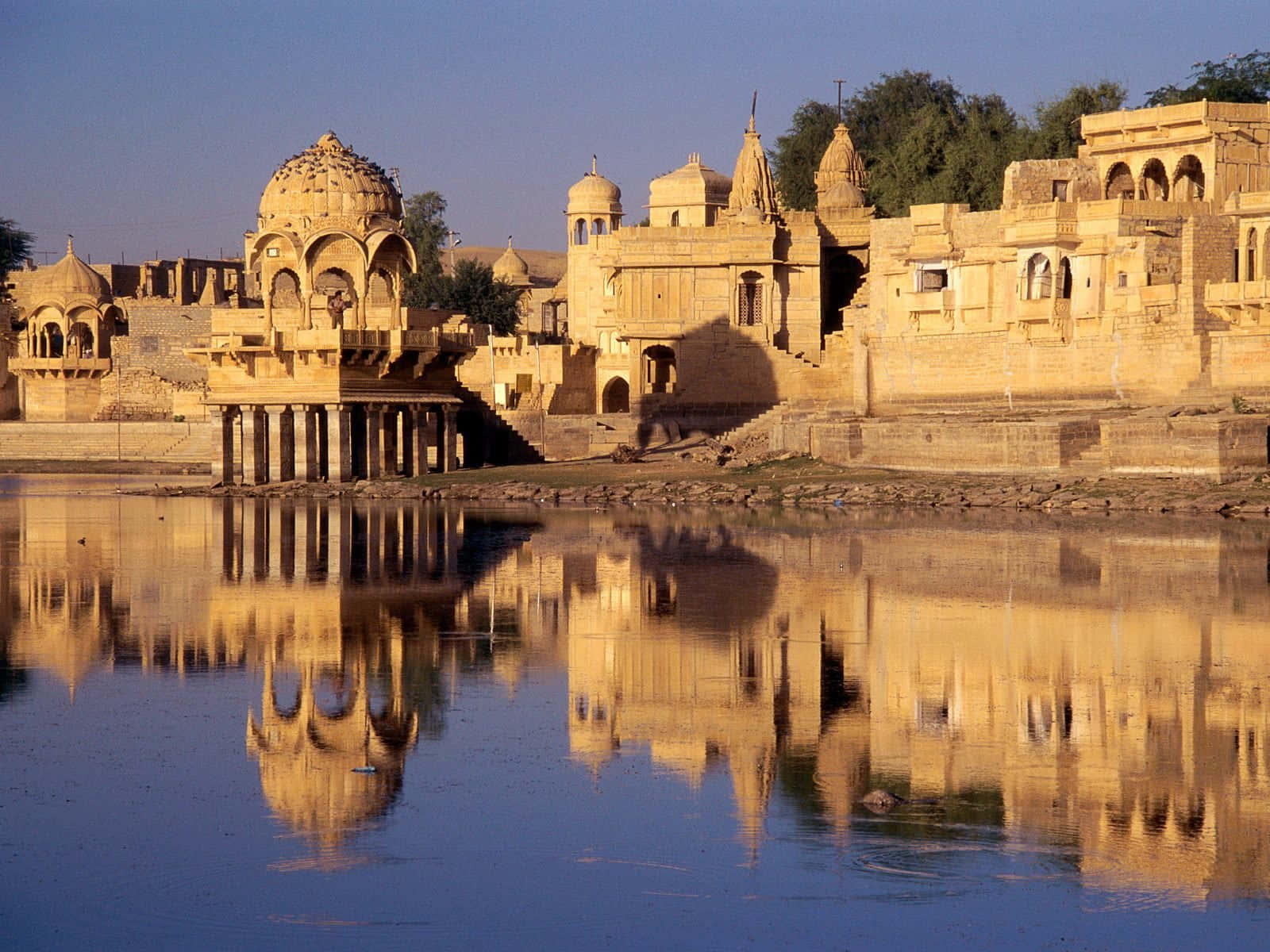 Rajasthan 桌布 壁紙 — 古老的金色砂岩宮殿建築群在清澈藍天下平靜的水面上完美倒映。