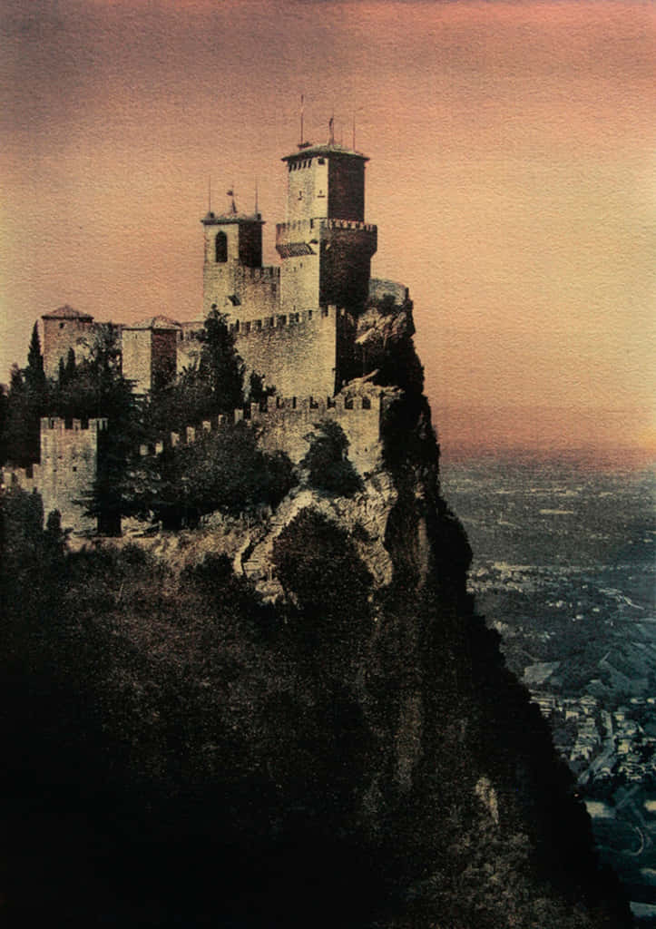 tower 桌布 壁紙 — 古老石城堡矗立在陡峭懸崖頂端，俯瞰日落時分廣闊的山谷。