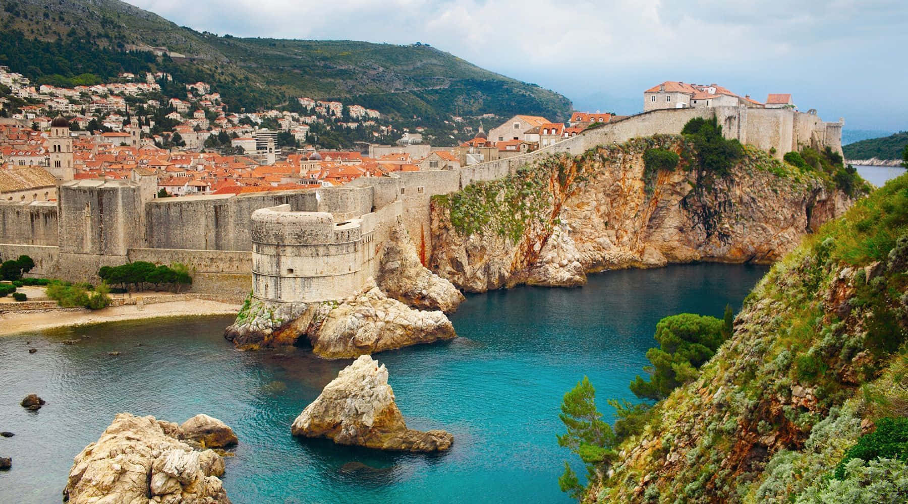 Croatia 桌布 壁紙 — 古老石堡依附在岩石峭壁上，俯瞰著碧綠的海水，山坡上坐落著陶瓦屋頂的小鎮。