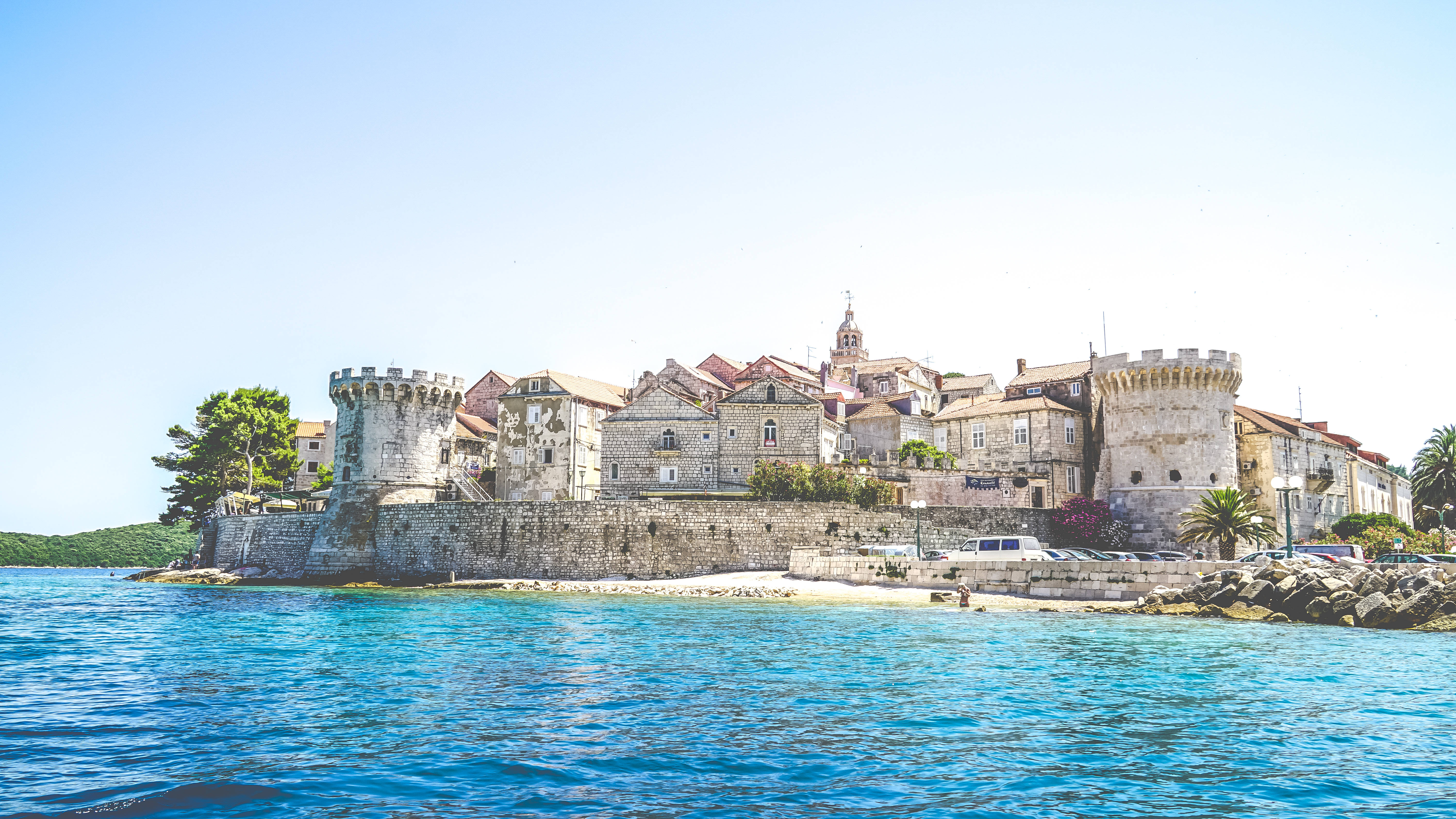 Croatia 桌布 壁紙 — 古老石堡和城鎮依附在岩石海岸上，下方是碧綠的海水，上方是清澈的藍天。