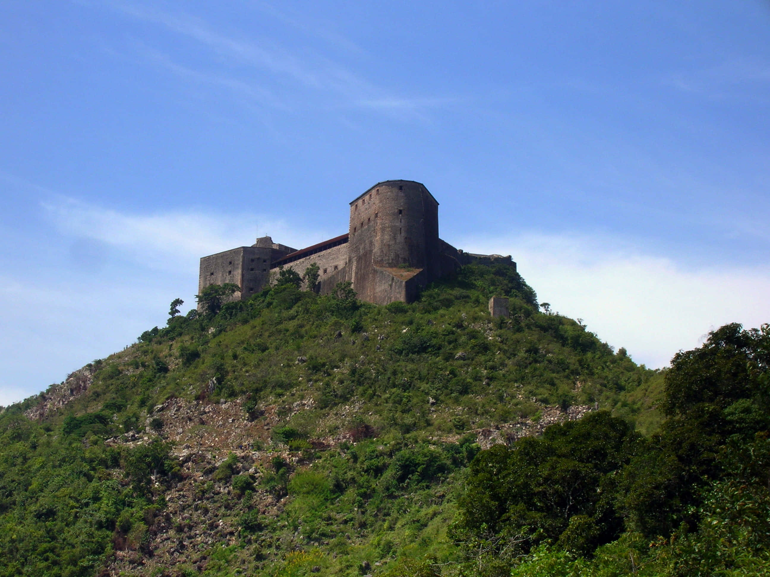 Fortress 桌布 壁紙 — 古老石堡坐落於翠綠山丘上，藍天白雲清晰可見。