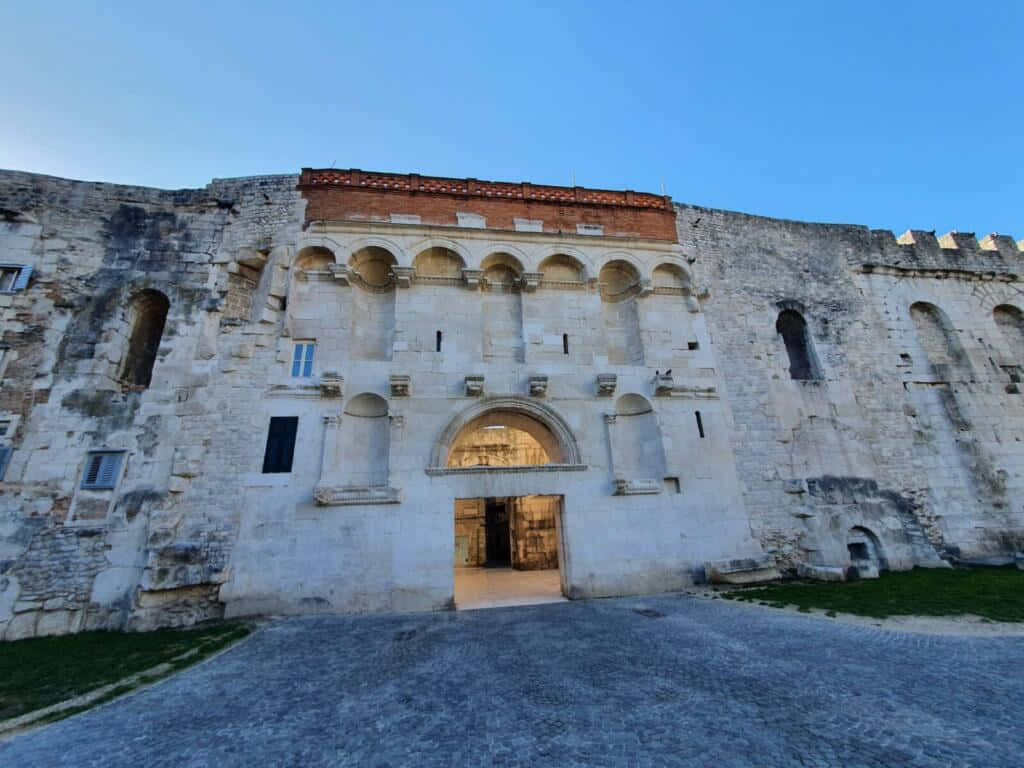 Croatia 桌布 壁紙 — 古老石堡大門，拱形入口，牆壁風化，襯托清澈藍天。