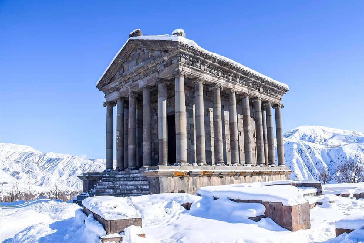 Architecture 桌布 壁紙 — 古老石廟，雪覆蓋的柱子，在清澈藍天下，背景是白雪覆蓋的山脈，氣勢雄偉。