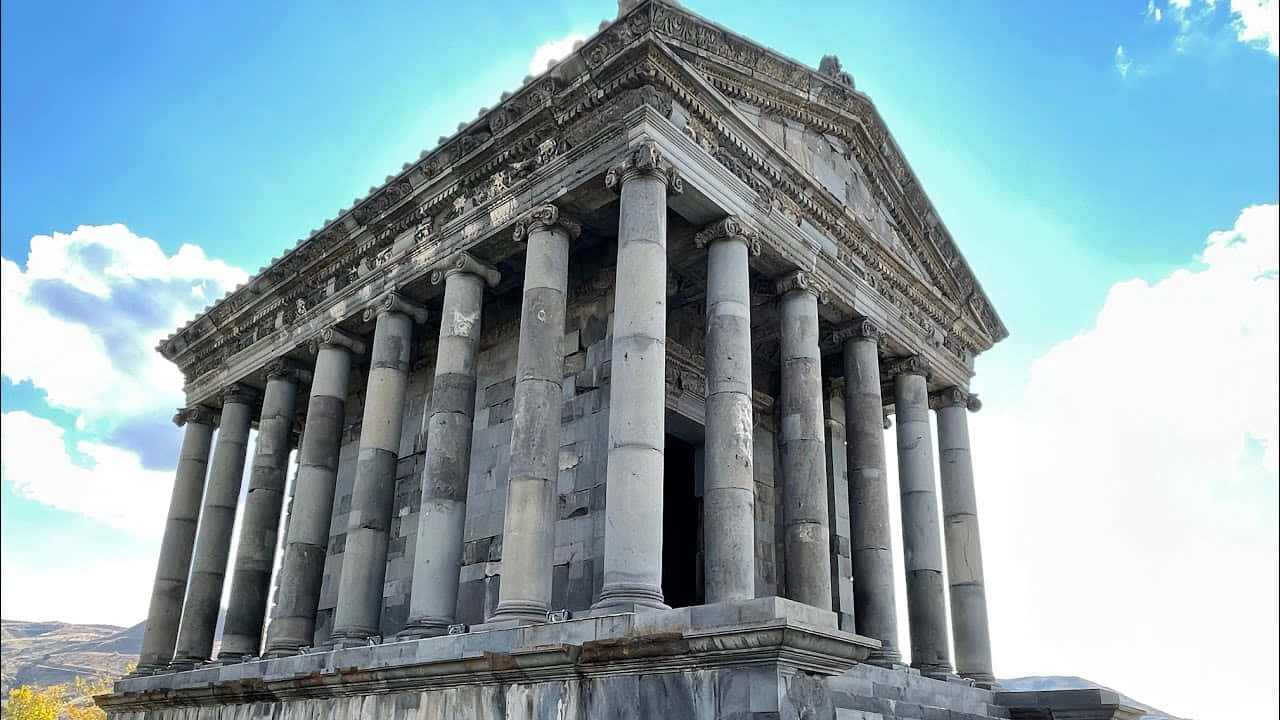 Building 桌布 壁紙 — 古老石廟，高柱聳立，在藍天白雲下顯得莊嚴宏偉。