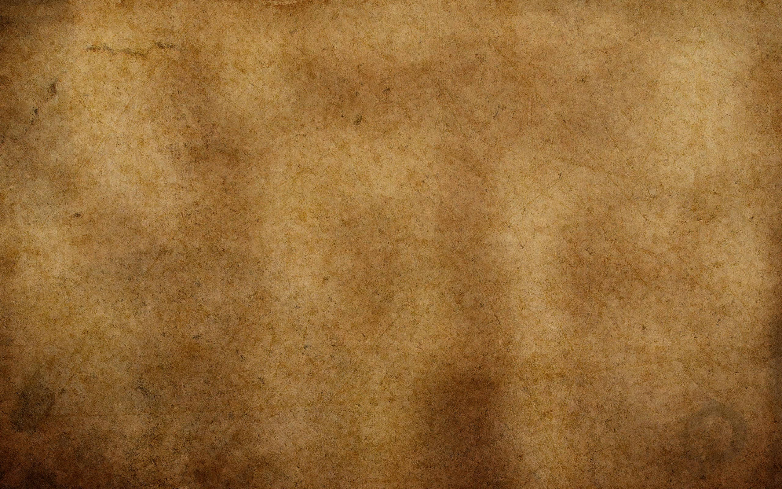 Gold Texture 桌布 壁紙 — 古老羊皮紙的特寫，帶有不均勻的棕色污漬和微妙的紋理變化。