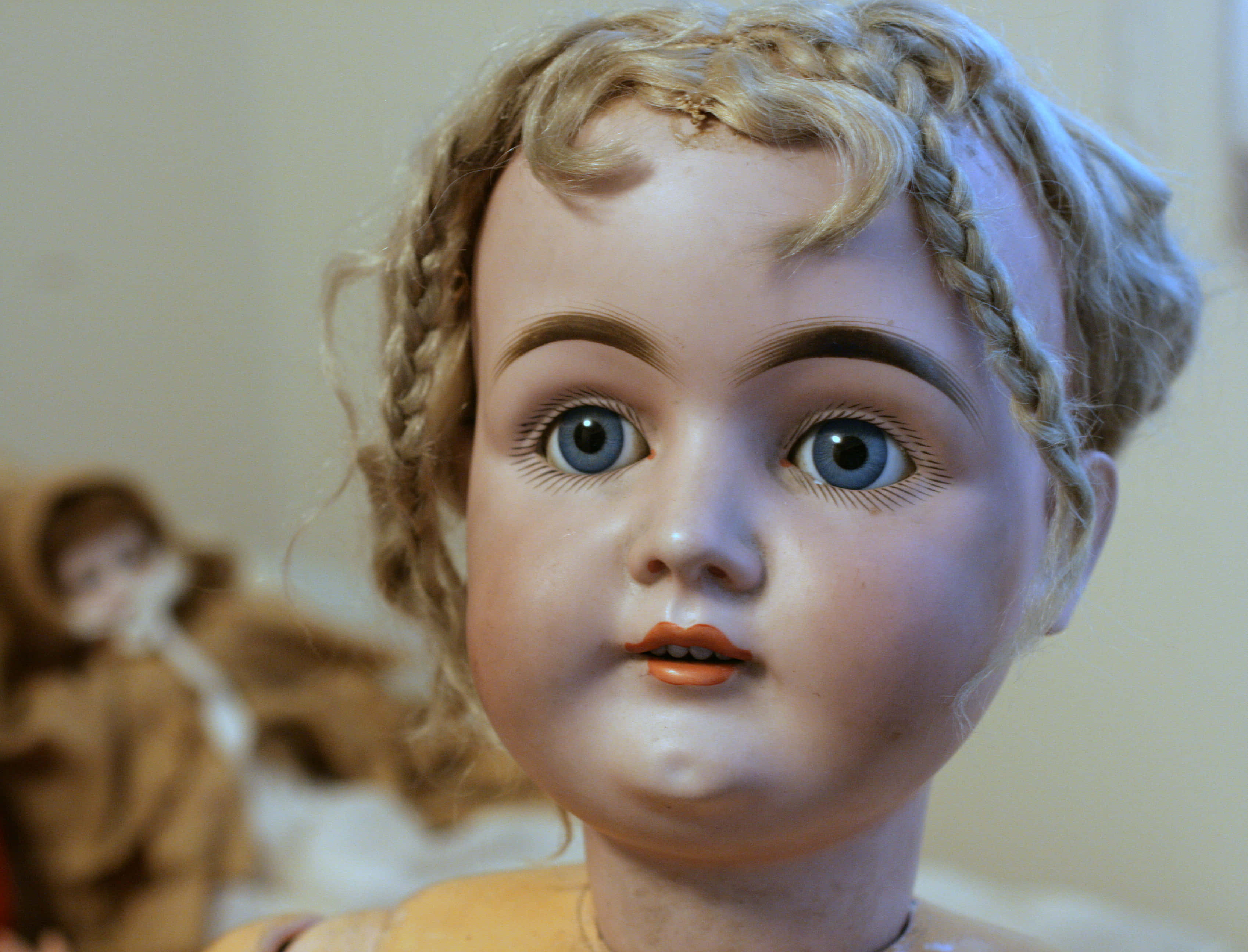 Doll 桌布 壁紙 — 古董娃娃特寫，藍色眼睛，辮子金髮，橙色嘴唇，柔和模糊的背景。