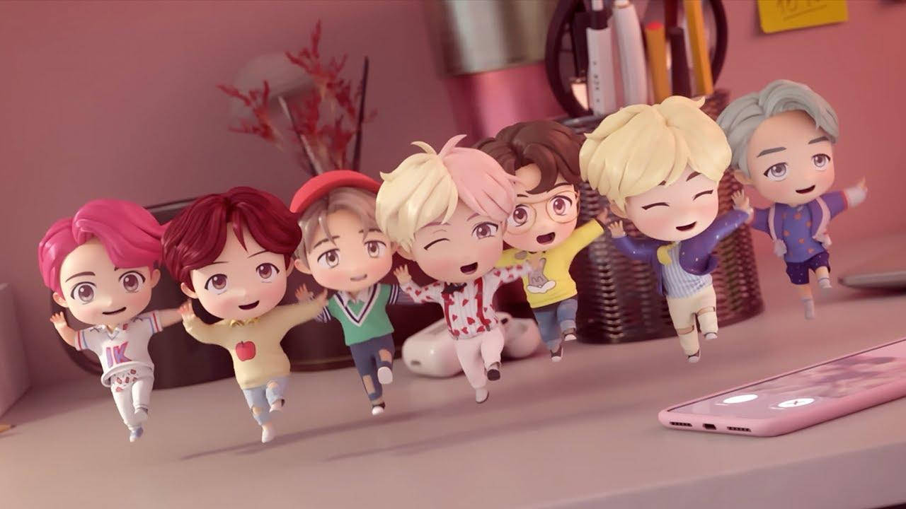 BTS 筆電 桌布 壁紙 — 可愛的Q版動漫角色在粉紅色的桌子上歡快地跳躍，背景有智慧型手機和文具。