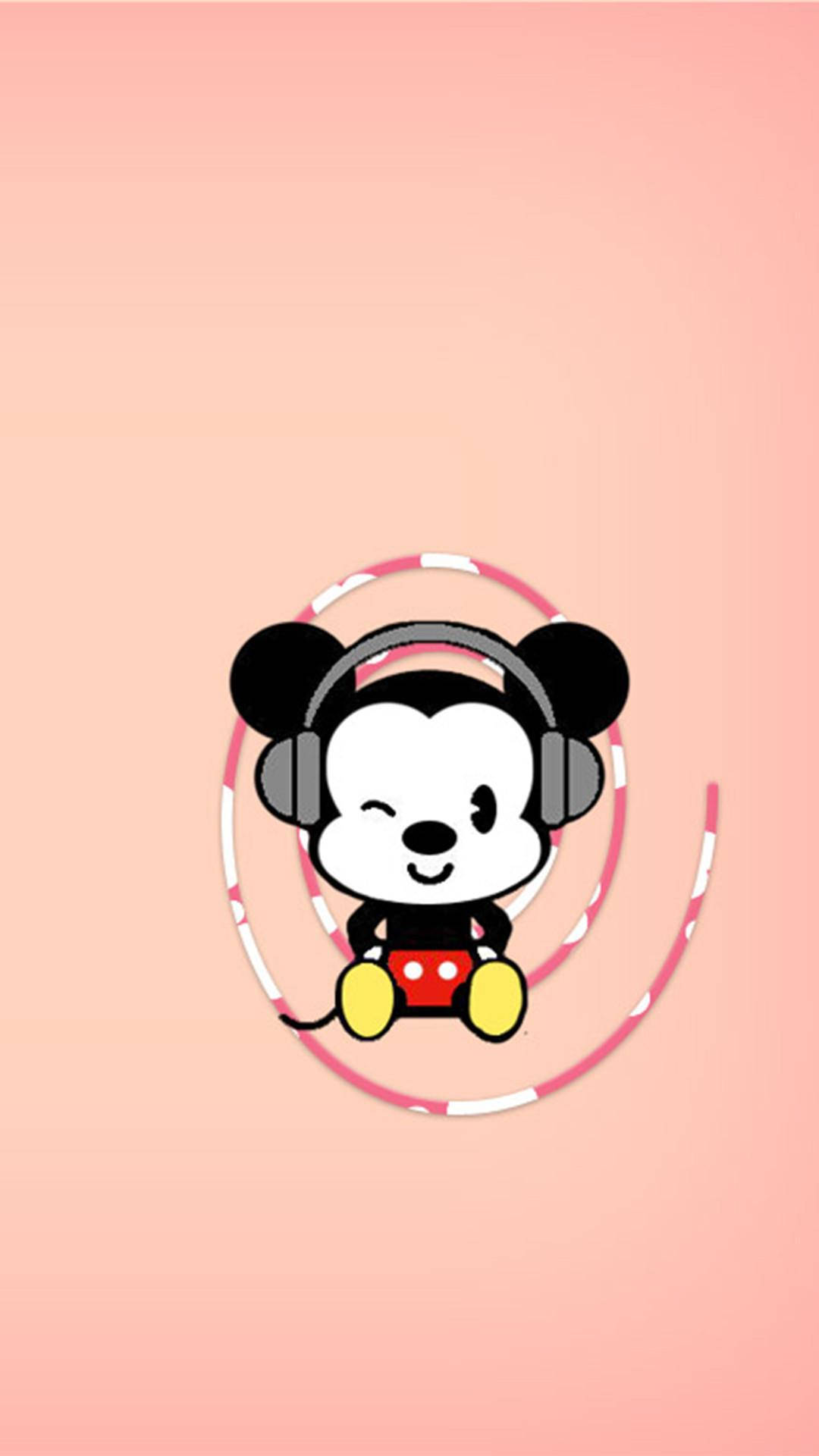 Mickey 桌布 壁紙 — 可愛的卡通米奇老鼠戴著耳機，坐在粉紅色和白色的呼拉圈內，背景是柔和的桃色。