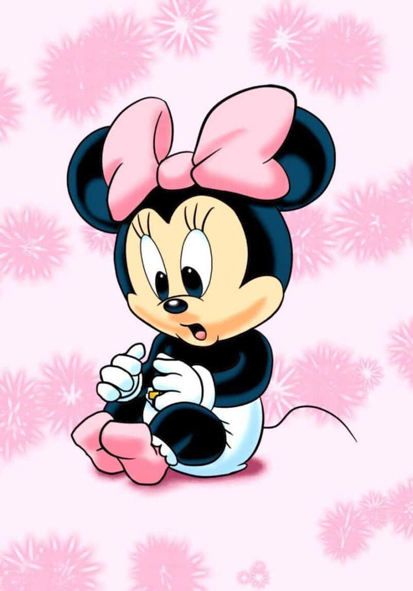 Minnie Mouse Pink 桌布 壁紙 — 可愛的米妮老鼠寶寶盤腿坐在柔軟的粉紅色背景前，背景有毛茸茸的花卉圖案。