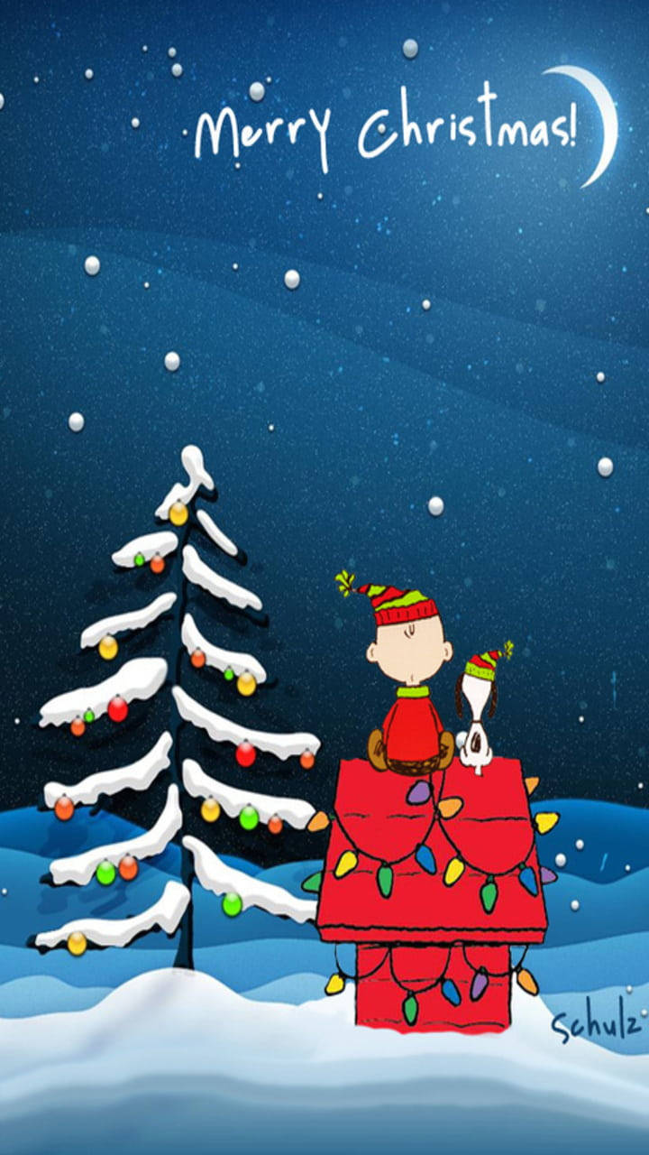 Snoopy Christmas 桌布 壁紙 — 史努比和查理布朗戴著節日帽子，在星空和彎月下裝飾著被雪覆蓋的聖誕樹。