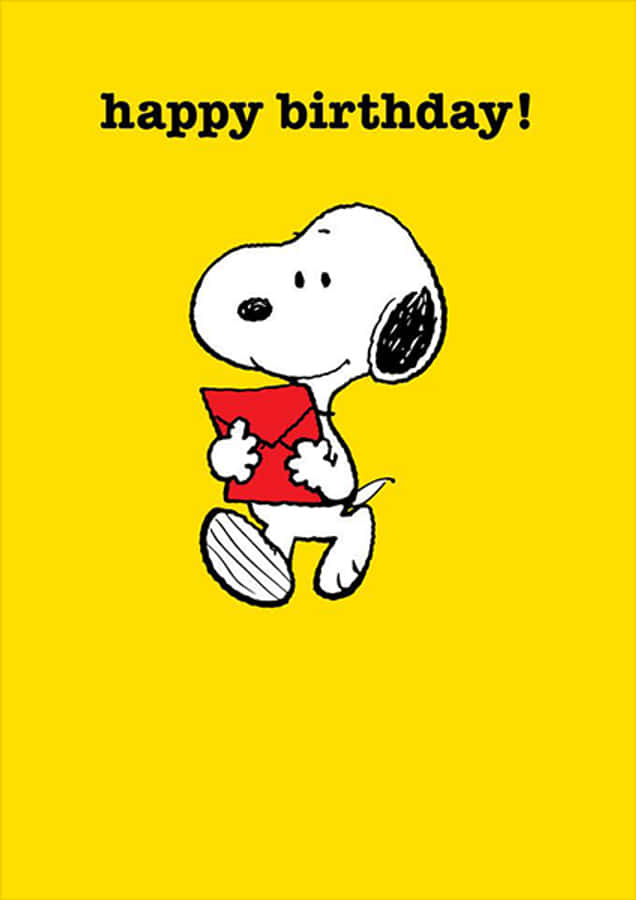 Charlie Brown Birthday 桌布 壁紙 — 史努比在明亮的黃色背景上拿著一個紅色信封，上面有 'happy birthday!' 文字。