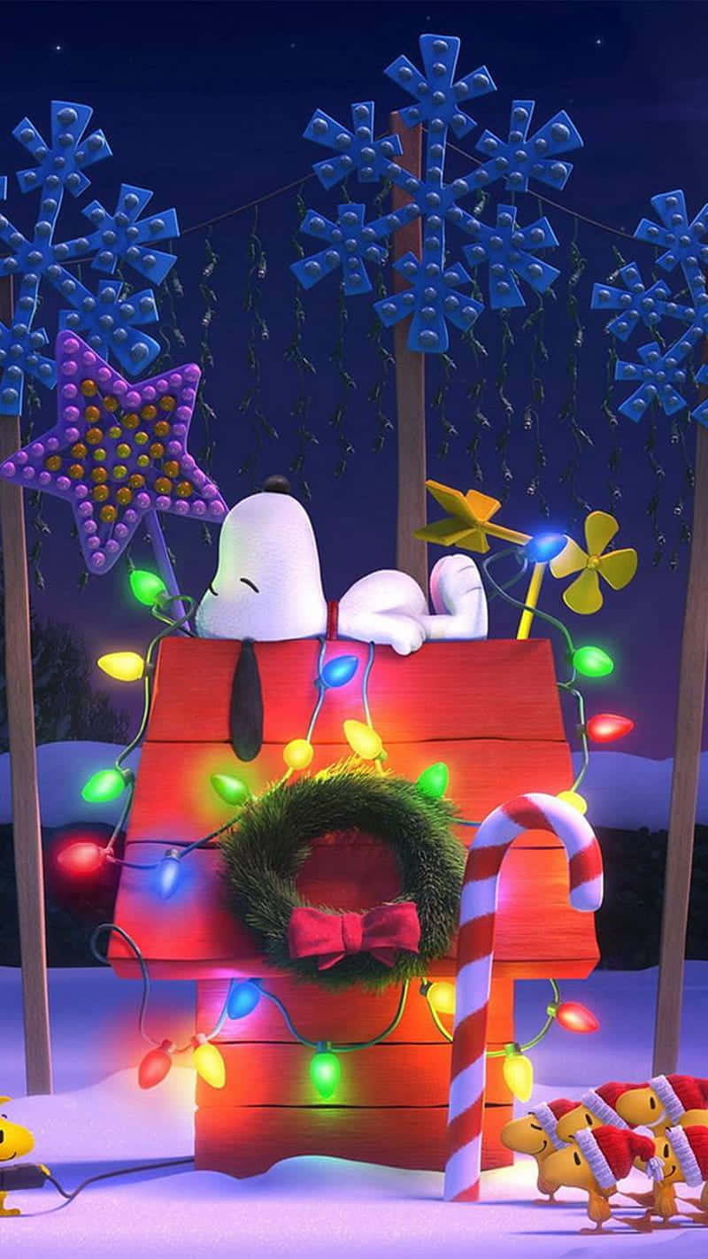 花生漫畫 桌布 壁紙 — 史努比在雪夜星空下，安詳地睡在他那裝飾著節日燈飾、花環和拐杖糖的紅色狗屋上。
