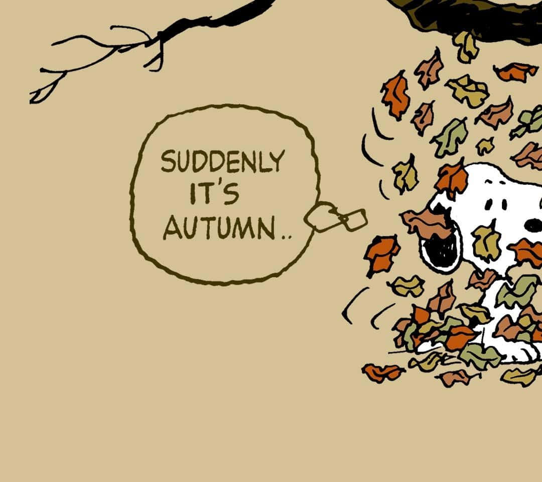 Snoopy Thanksgiving 桌布 壁紙 — 史努比被埋在秋天的落葉下，有一個對話氣泡突然宣佈現在是秋天。