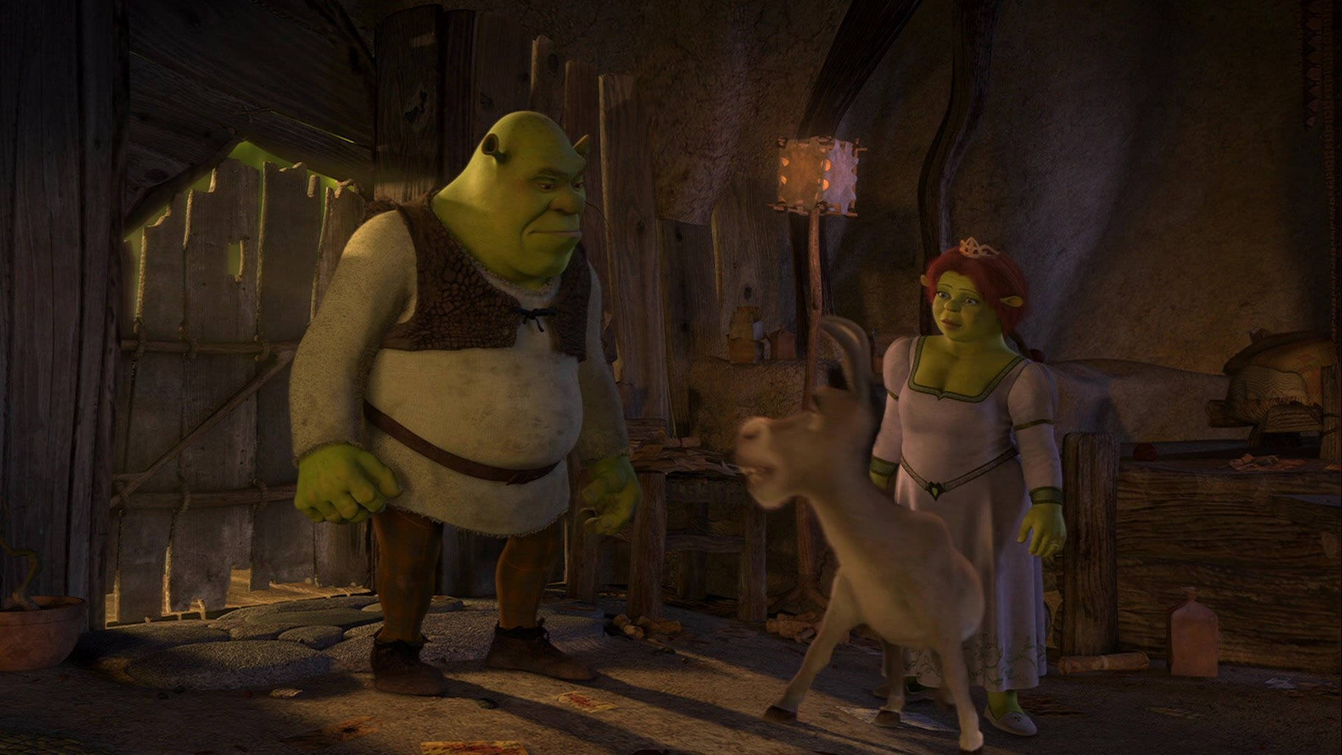 Shrek 2 桌布 壁紙 — 史瑞克、費歐娜和驢子站在一個昏暗的鄉村小屋中，木牆和掛燈散發出溫暖的光芒。