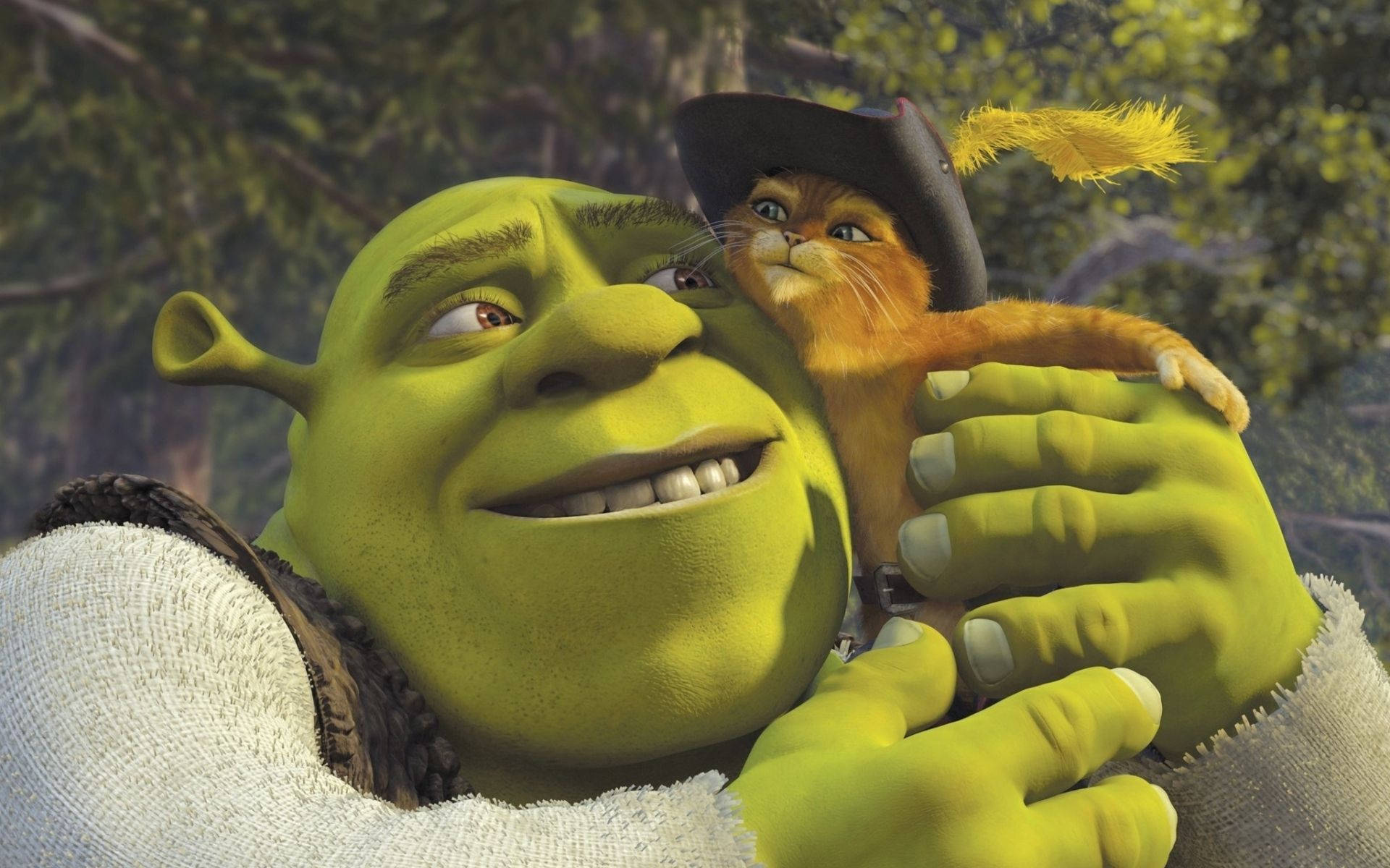 Shrek 桌布 壁紙 — 史瑞克在森林場景中抱著一隻戴著黑色帽子、帽上有黃色羽毛的小小橘貓。