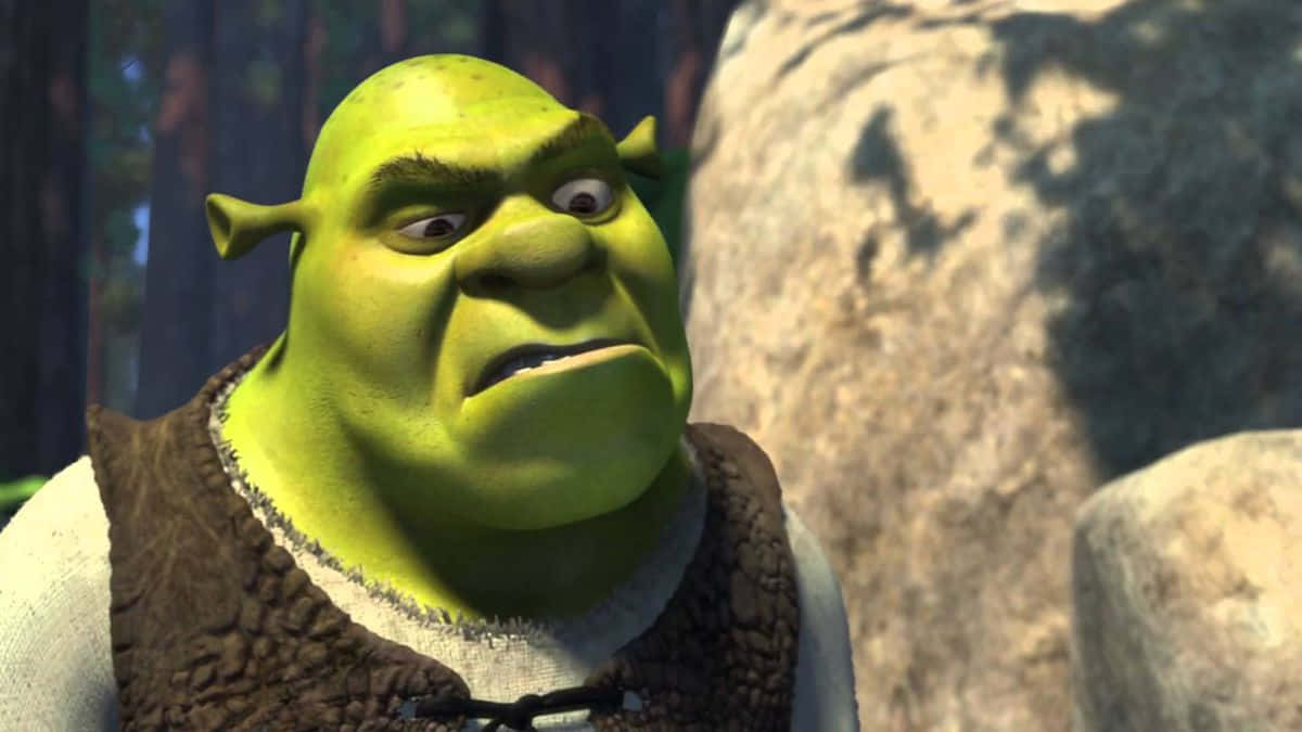 Shrek Funny 桌布 壁紙 — 史瑞克近距離特寫，表情暴躁，站在森林中，旁邊有大岩石。