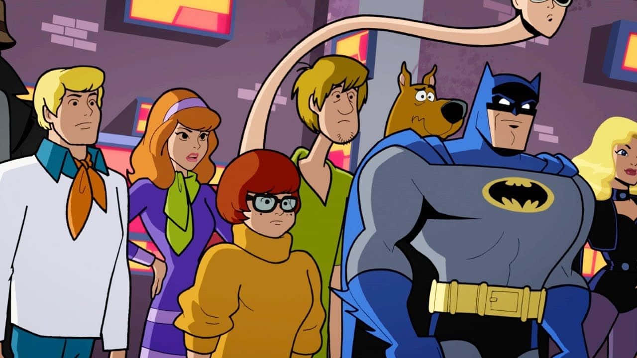 Batman The Brave And The Bold 桌布 壁紙 — 史酷比幫和蝙蝠俠一起站在一個色彩繽紛的卡通場景中，一隻長頸生物在他們上方若隱若現。